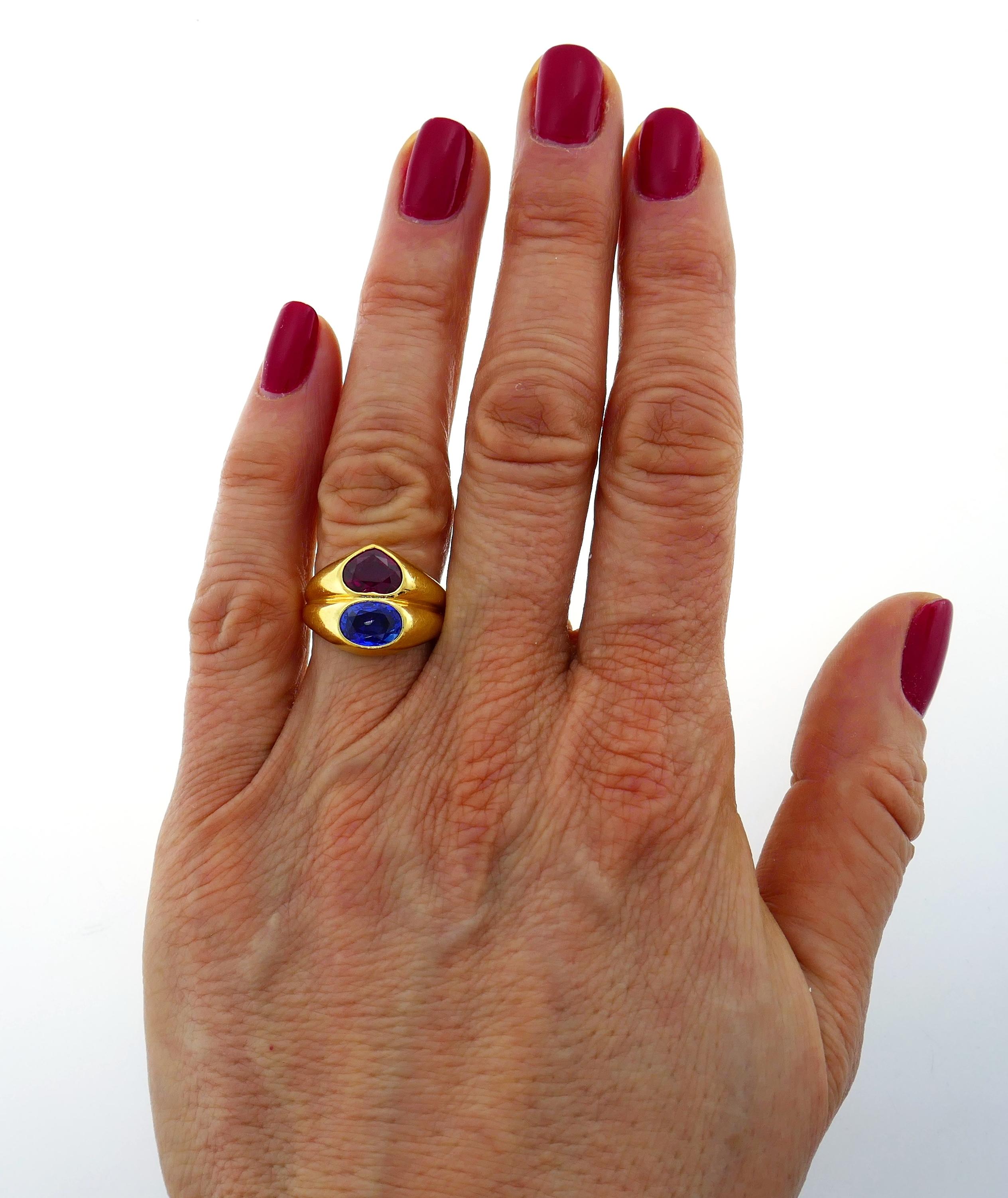 Beautiful Doppio ring created by Bulgari in Italy in the 1980s. Features a 1.69-carat heart-shaped faceted ruby and a 1.57-carat oval faceted sapphire set in 18 karat yellow gold. Timeless, classy and wearable, the ring is a great addition to your