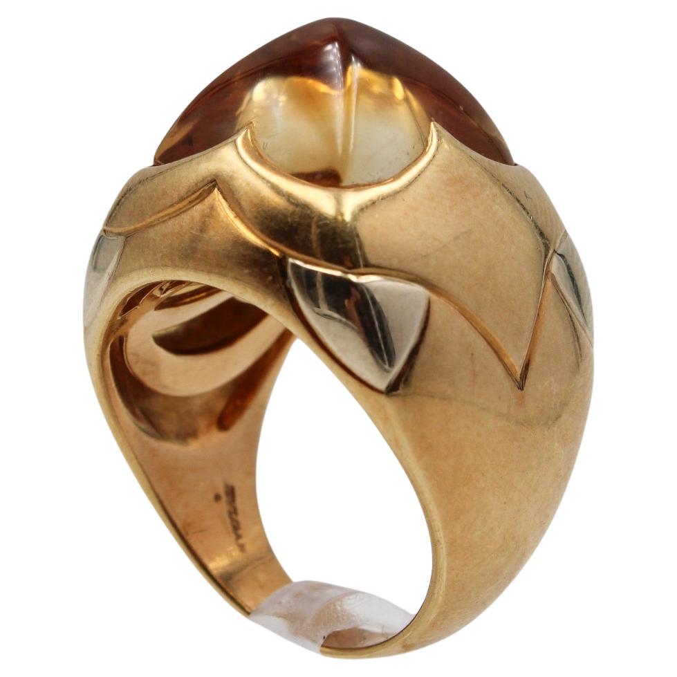 Dieser Vintage-Ring von Bulgari ist ein kühnes Statement, das die unverwechselbare Designsprache der Marke unterstreicht. Das Herzstück ist ein großer Citrin-Cabochon mit einem warmen Honigton, der in eine glatte Pyramidenkuppel geschliffen ist, die