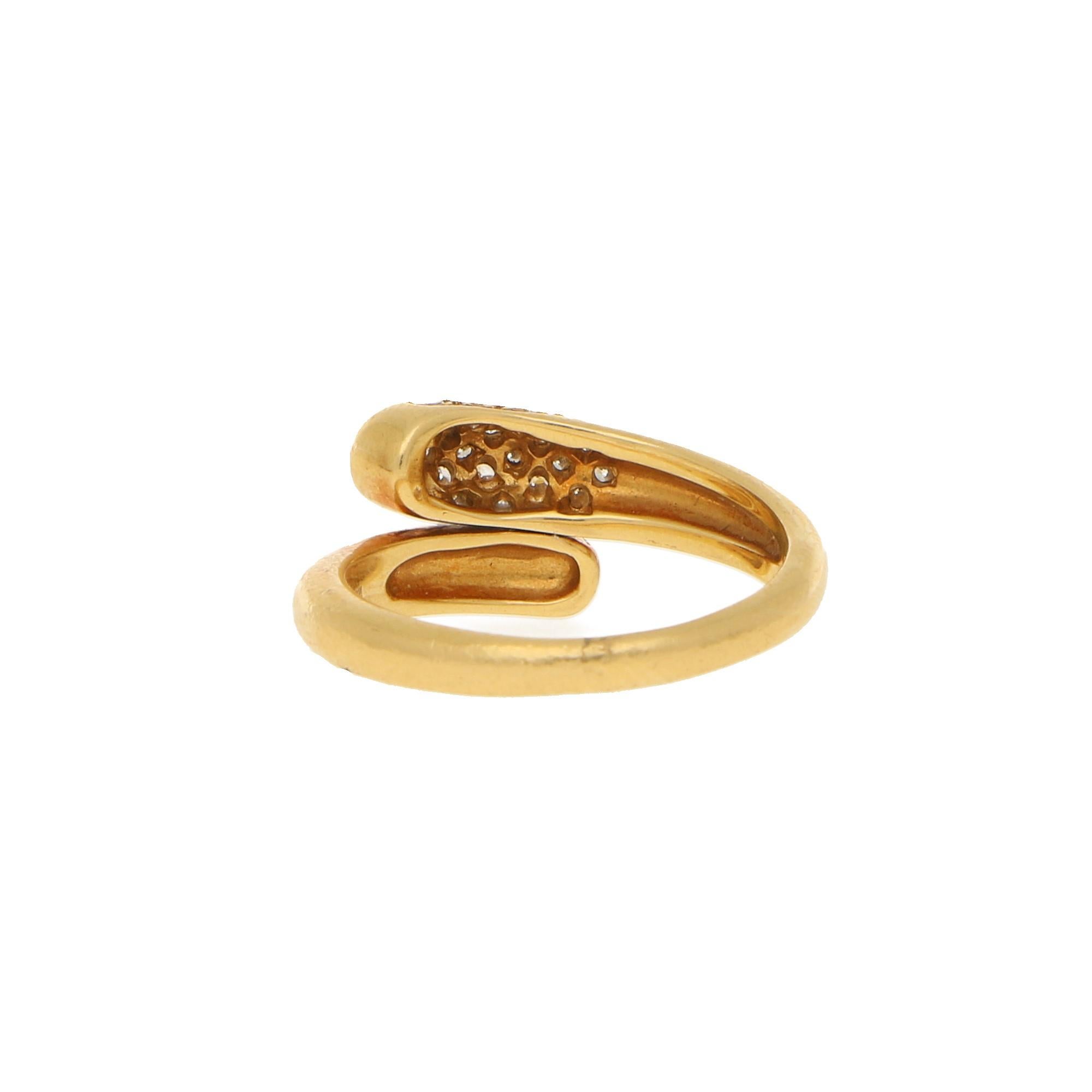 A vintage Bvlgari Serpenti ring in a crossover design set in 18k yellow gold. Within the crossover design one terminal is pave set with 19 round brilliant cut diamonds, totalling an approximate weight of 0.38ct, G/H colour and VS clarity. 

This