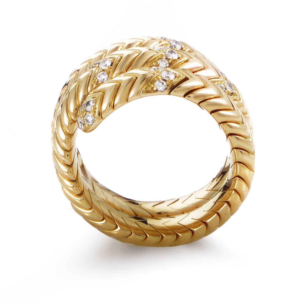 Easily recognizable as a distinctive mark of the brand, the dazzling pattern on the offbeat 18K yellow gold body of this astonishing ring from Bulgari creates an almost hypnotic allure enhanced by the addition of sparkling diamonds throughout.