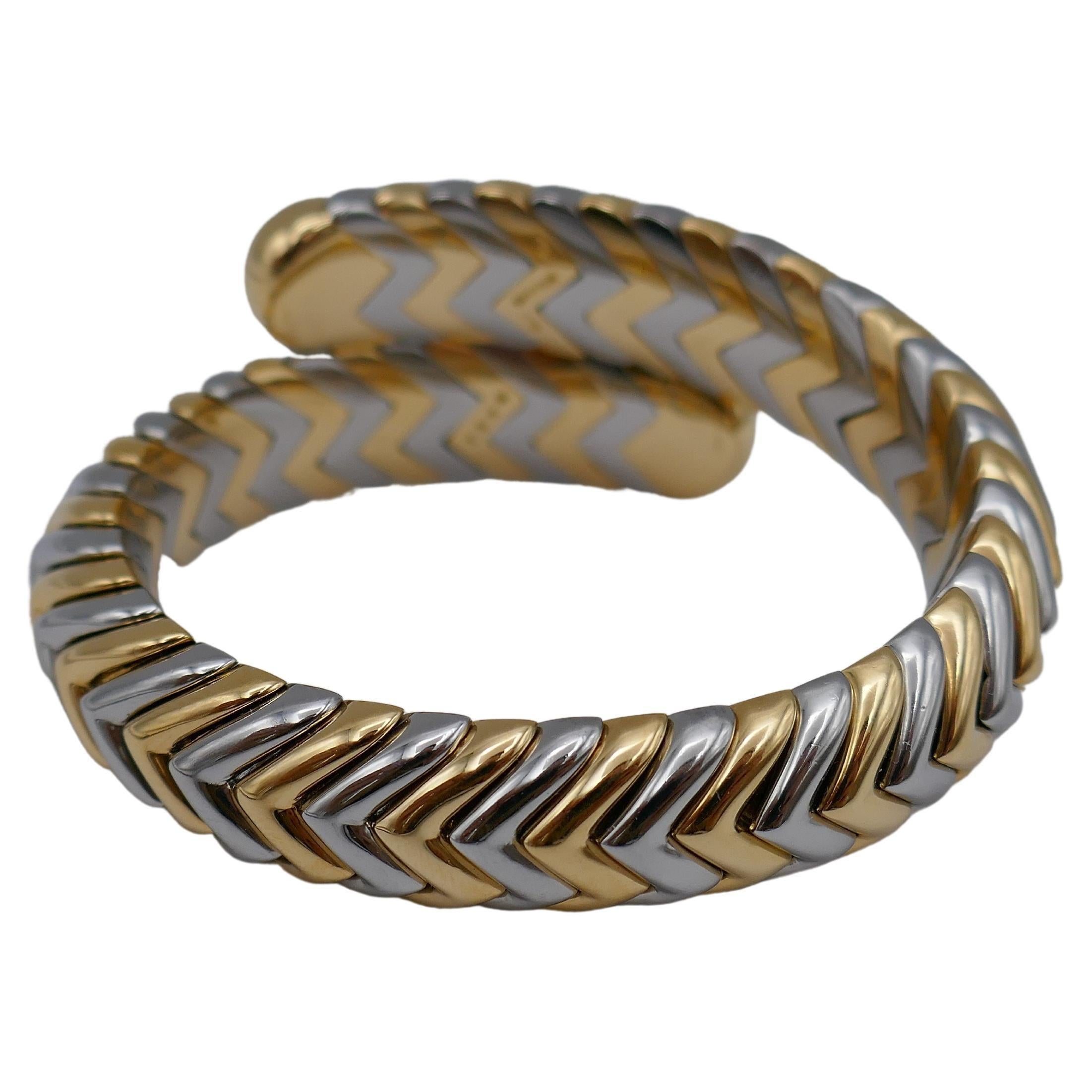 A celebrated Bulgari Spiga bracelet made of 18k gold and stainless steel.
Bulgari staple Spiga design implemented in the bypass Spiga bracelet. The coils are high-polished metal which creates a luxurious, glossy surface.
The herringbone links are
