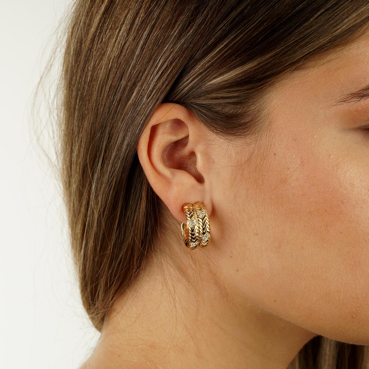 An iconic pair of Bulgari Spiga diamond earrings showcasing the chevron pattern adorned with the finest Bulgari round brilliant cut diamonds in 18k yellow gold.

.90