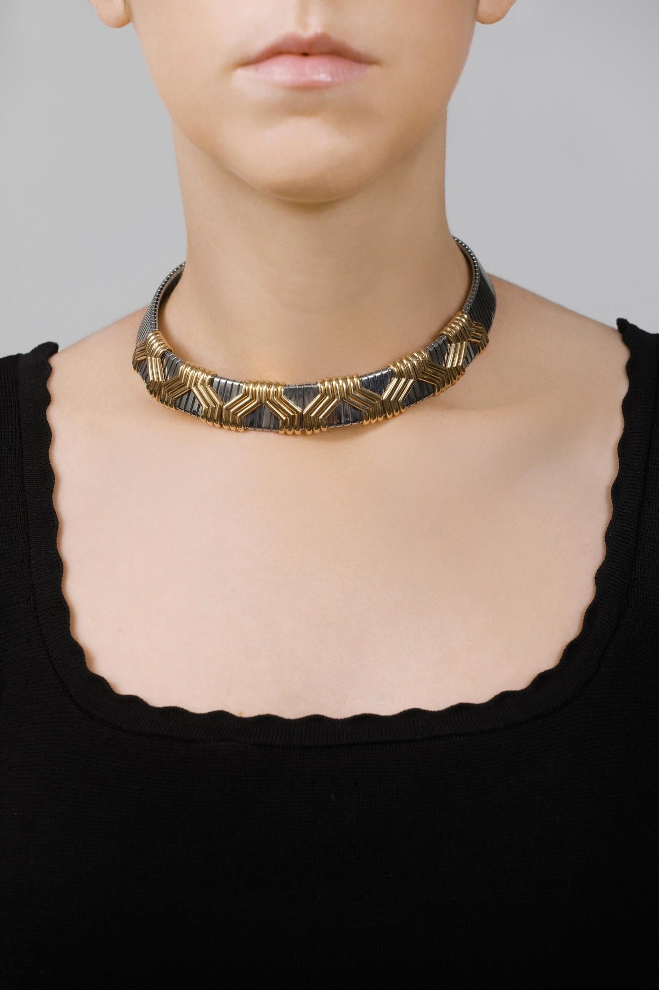 A chic Bulgari choker necklace composed of steel tubogas piping, the front embellished with gold geometric motifs. Maximum length approximately 430mm, signed Bulgari, Italian assay mark for gold and maker's mark.