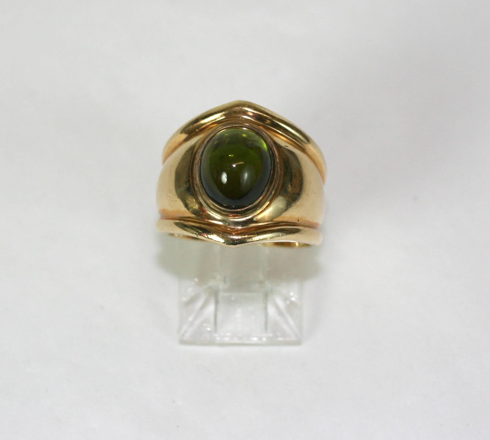 Bulgari style ring of 14k gold with large green tourmaline cabochon. Nice quality, heavy shank, very wearable ring. 1980's USA. 
Size 5.5 US.  Approx .65