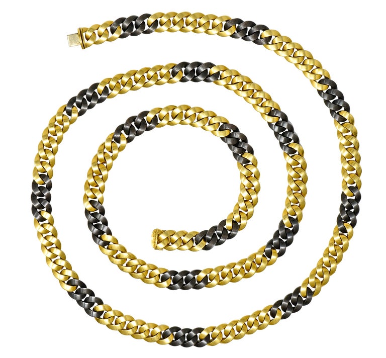 Designed as a curb link style chain with an alternating pattern of gold and steel links. Gold is high polished, and steel is oxidized black. Completed by hidden clasp closure with hinged safety. Stamped K18 for 18 karat gold and tested as steel.