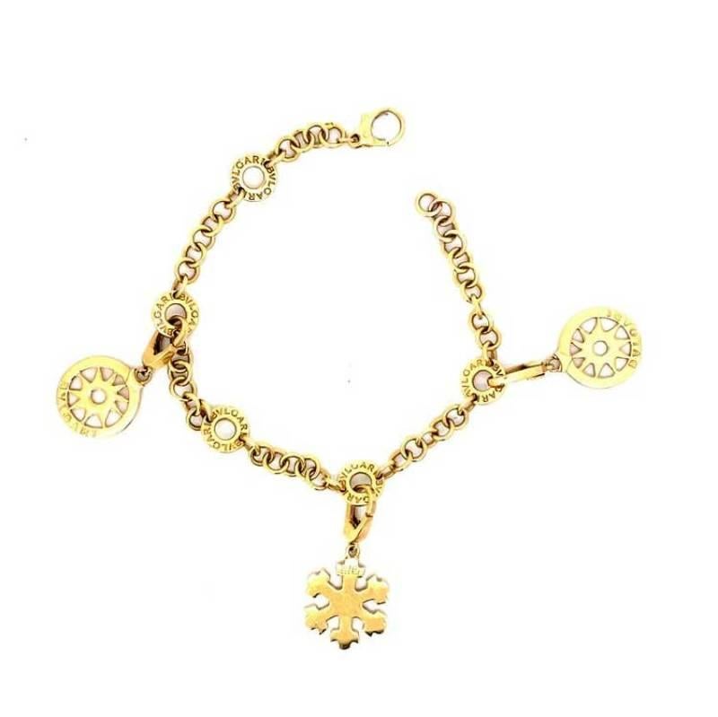 A stunning everyday Bulgari bracelet adorned with three charms, including two tondo soles and a diamond-studded snowflake. The 18k yellow gold bracelet is elegantly signed by Bulgari in multiple locations.
The bracelet measures 7 inches. The tondo