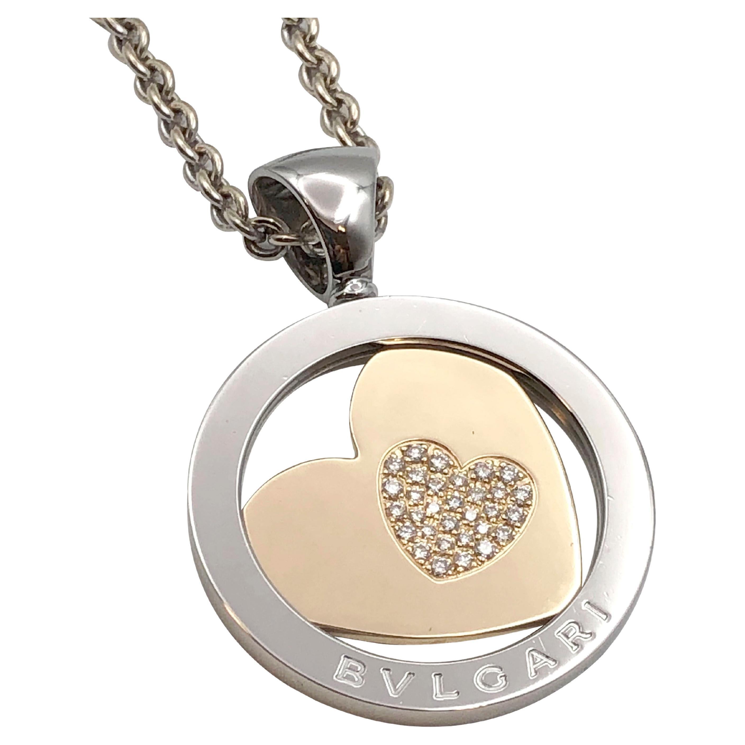 Circa:  2015 Bulgari Tondo Collection Necklace, 1 1/2 inch X 1 1/4 inch Circular pendant of Stainless Steel with an 18K Yellow Gold Heart with round Brilliant cut diamonds set into the very center. Suspended from a 27 inch 18K White Gold adjustable