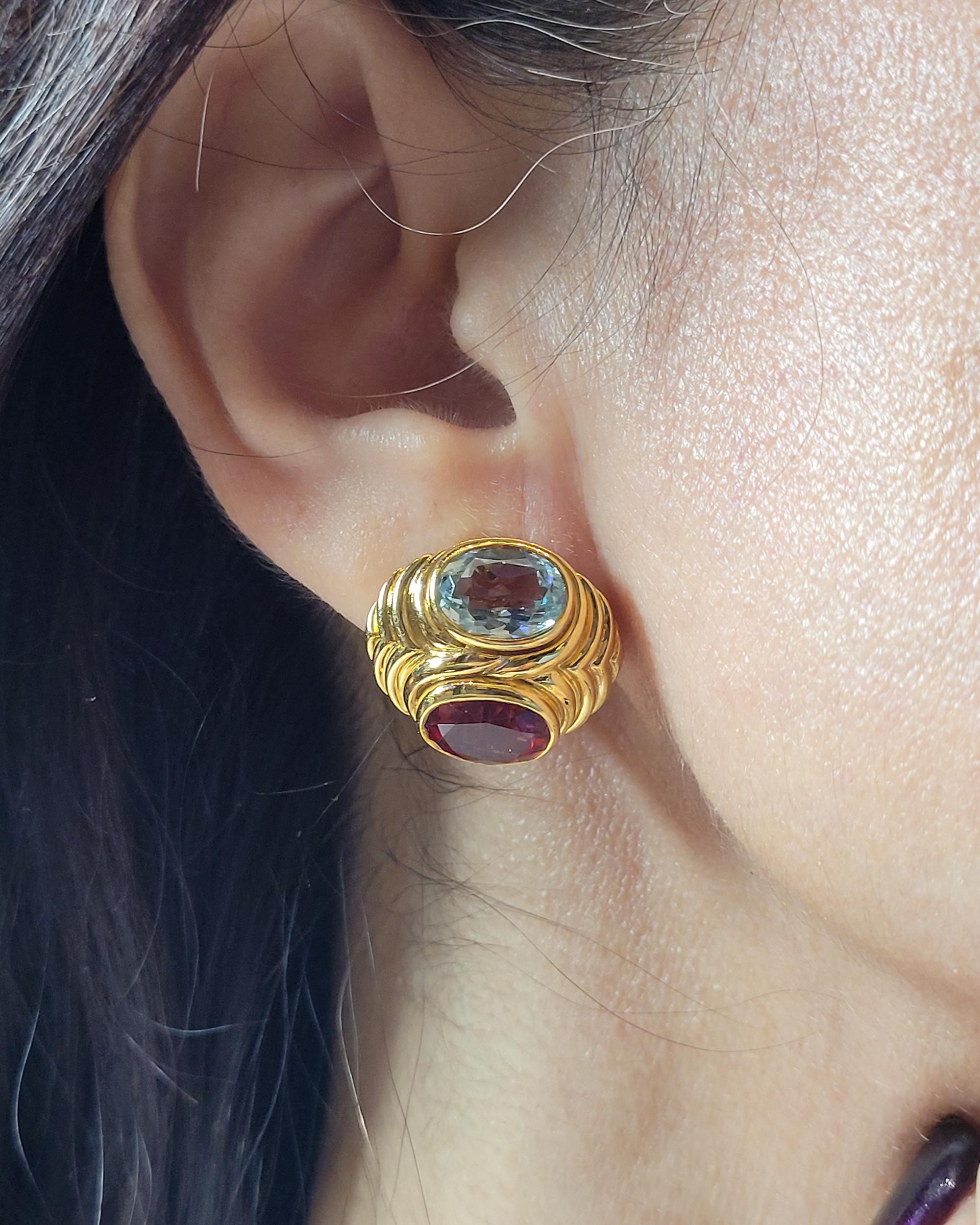 Beautiful earrings comprising of two oval London topaz stones and two oval rubelite stones mounted in 18k yellow gold.
Created by Bvlgari.
Weight of the earrings is 22.05 grams. 
Signed and numbered.

