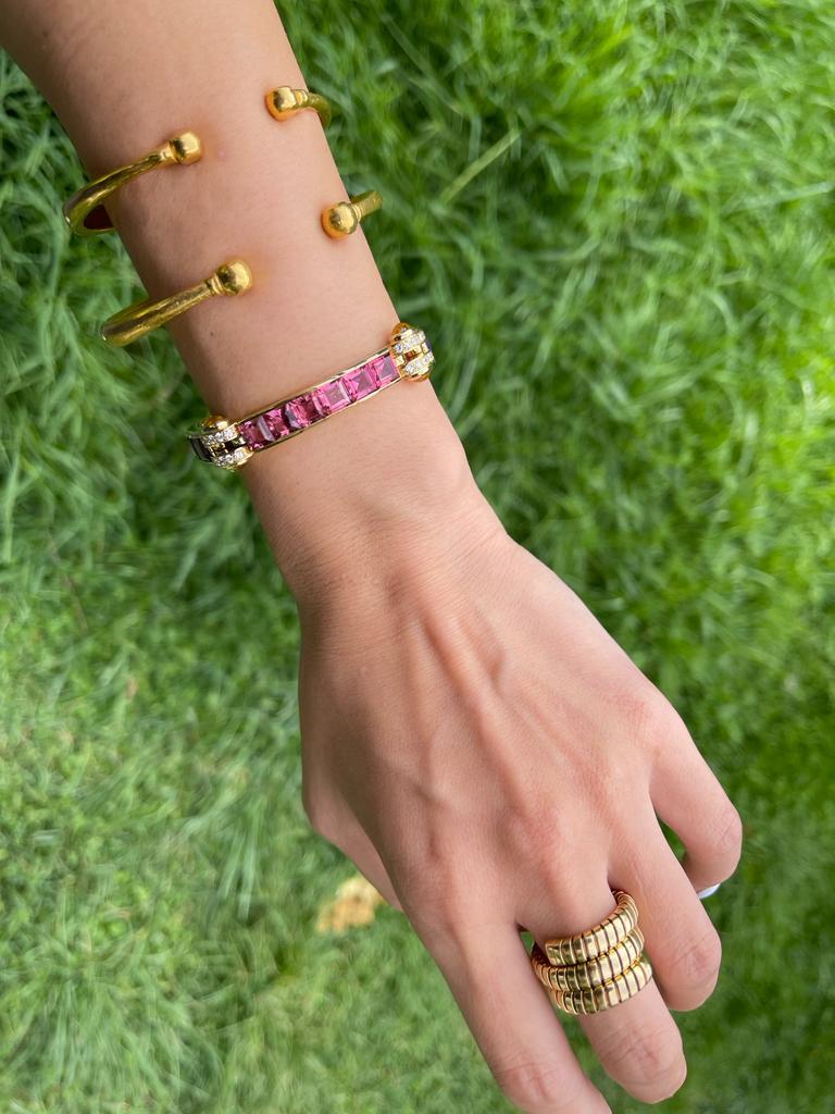 An 18 karat yellow gold pink tourmaline, amethyst, diamond and citrine Bulgari bracelet. Circa 1970

Designed as a curb link chain, featuring three mobile plaques, set with pink tourmaline and amethyst princess cut, and two fixed clasp set with