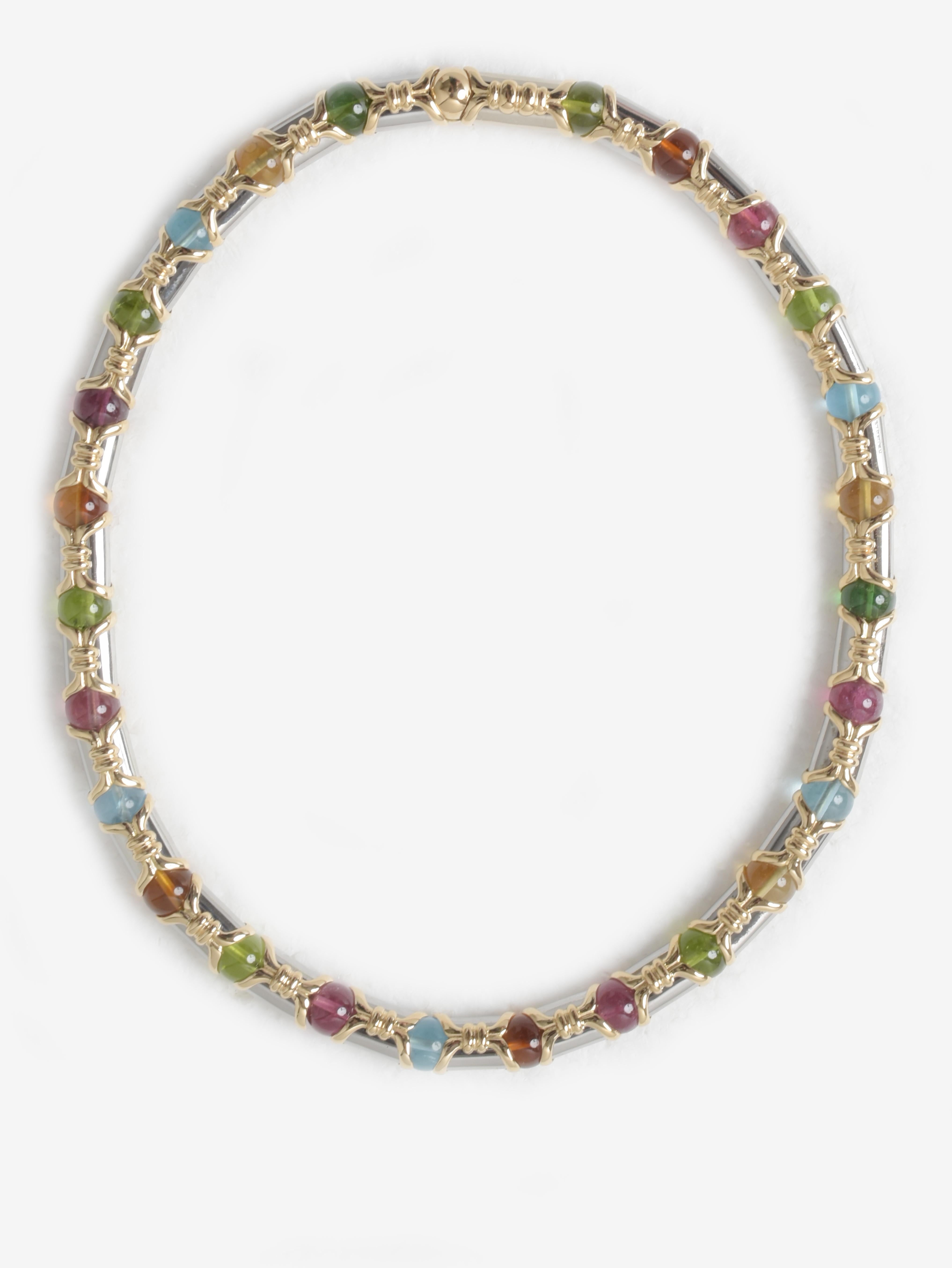 Bulgari Tubini Gold And Silver Necklace And Bracelet Set With Colored Stones is a coordinated set that is comprised of choker necklace and bracelet made of silver and gold piping alternating with stones of different colors. From the 1980s, it is