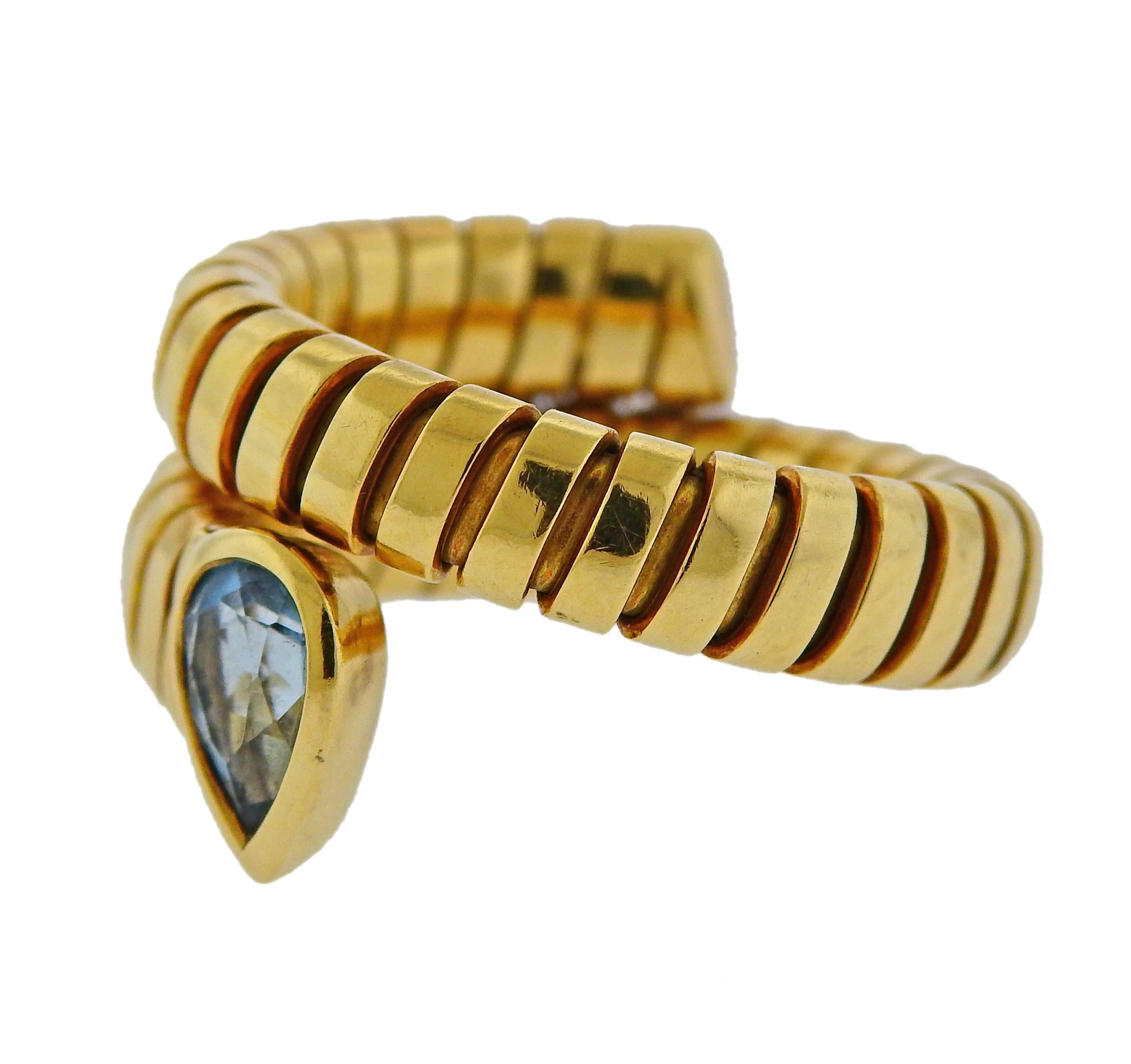 Bvlgari 18k yellow gold wrap ring from Tubogas collection, set with blue topaz gemstone. Ring size - 6-6.5 (slightly flexible) , ring is 14mm wide. Weight is 11.4 grams, Marked Bvlgari, Italian mark, 750.

