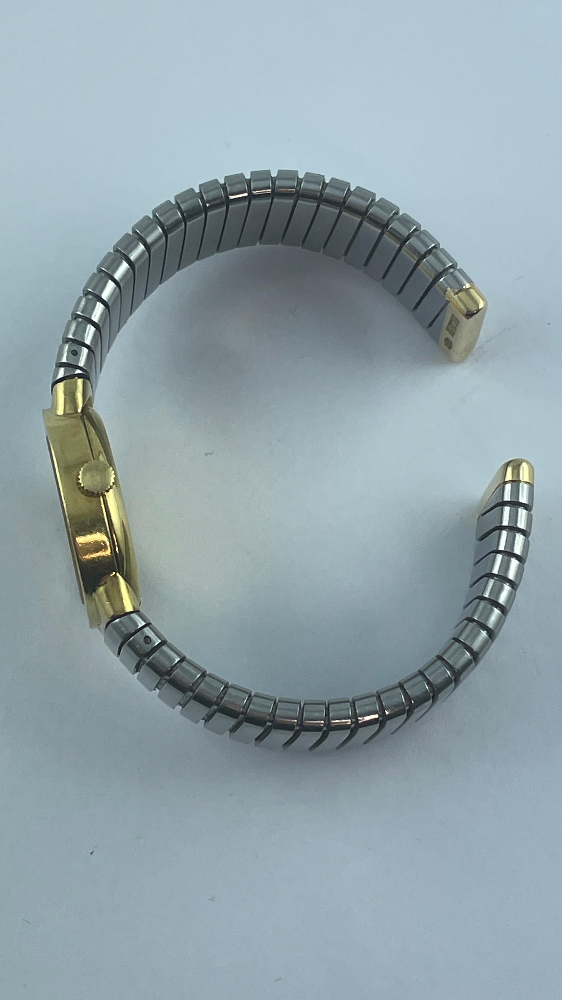 Classic 18k gold and steel Tubogas bracelet watch by Bvlgari, with black dial and manual winding movement. 
Bracelet will fix approx. 7'' wrist, case is 23mm in diameter, bracelet is 15mm wide. 
