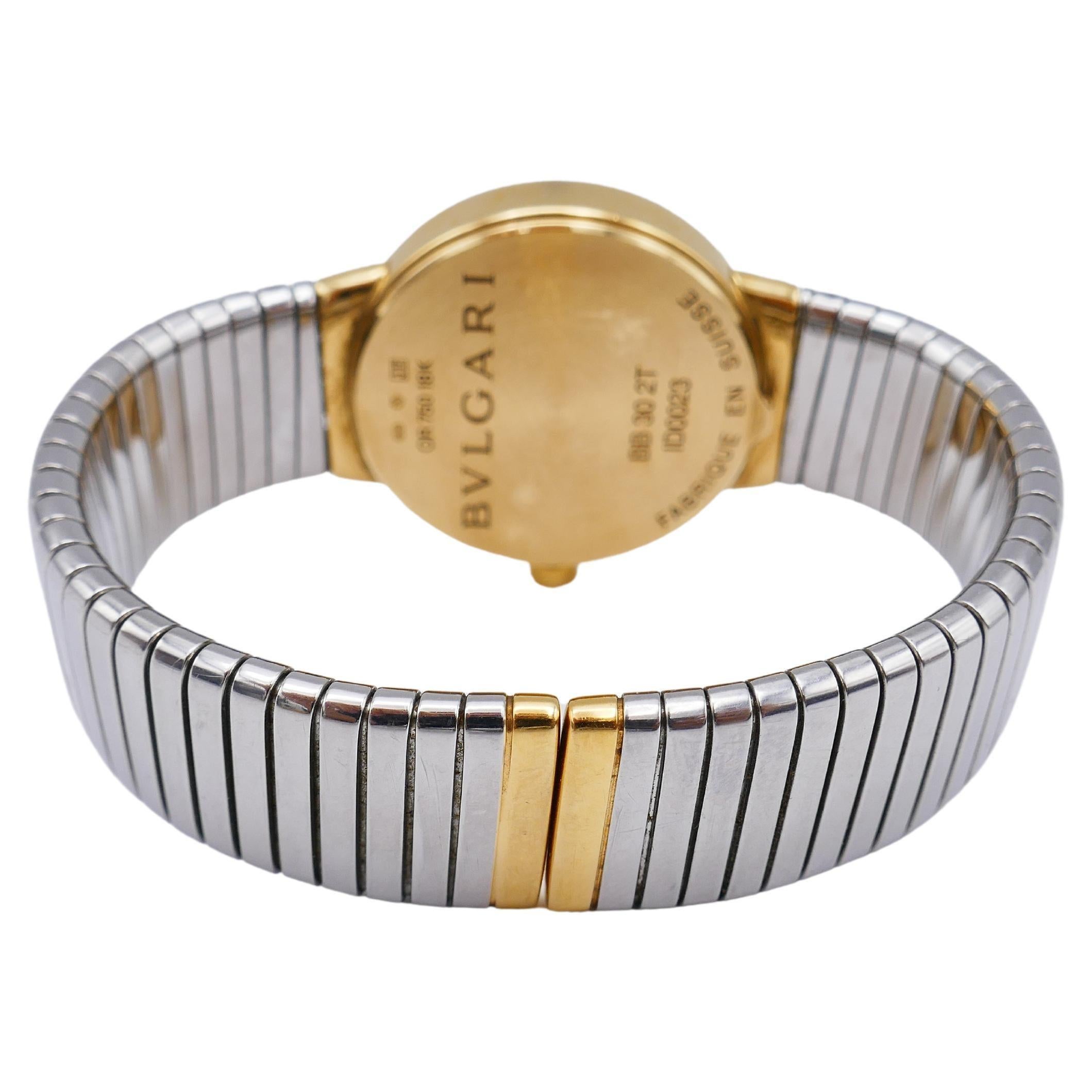 Eine Bulgari Tubogas Golduhr mit einem Edelstahlarmband. 
Das Modell ist BB 30, was die Größe des Gesichts (30 mm Durchmesser) angibt.
Sie ist mit einem Quarzwerk mit 8 Juwelen ausgestattet. 
Das Zifferblatt ist schwarz, die goldenen Zahlen sind