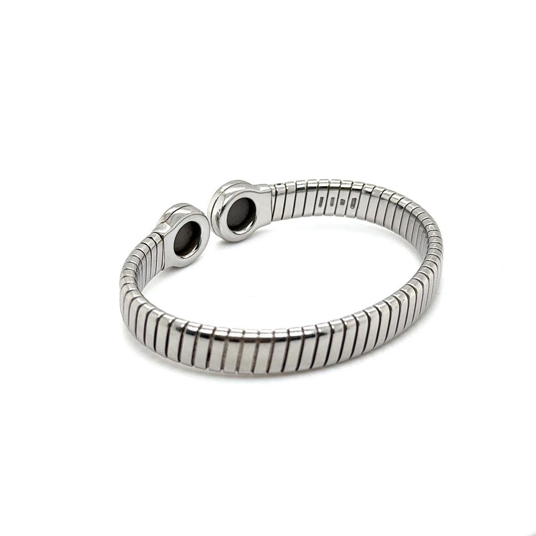 Beautiful cuff bracelet from famed designer Bulgari. From the Tubogas collection this elegant cuff design is crafted in stainless steel and highlights onyx gemstones.
The bangle shows a flew fit design and is easy to take on and off. The cuff weighs