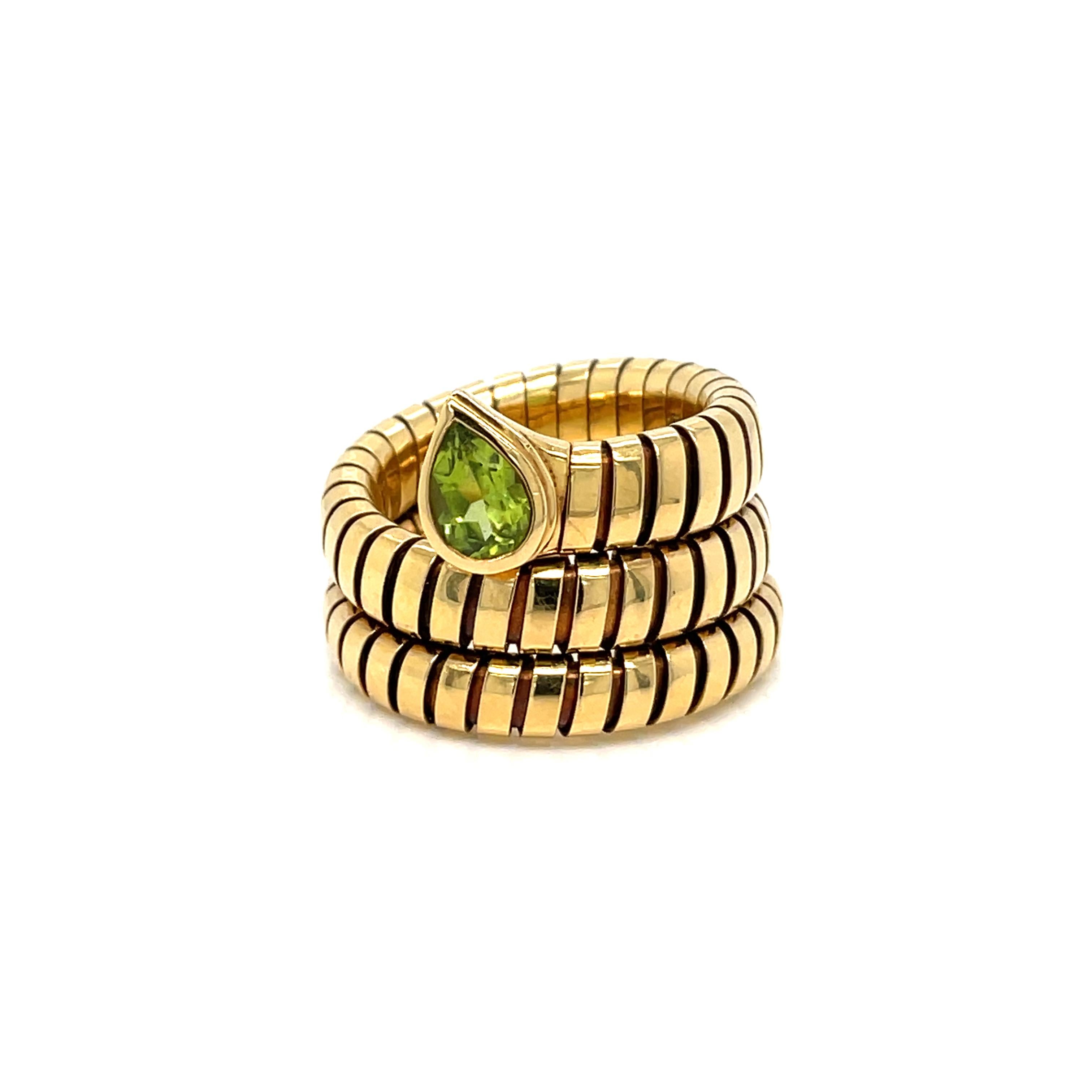An iconic Bulgari Tubogas ring circa 1980's showcasing 18k yellow gold in a perfectly balanced ring, set with a fancy pear-cut Peridot 
The ring measures a size 6. The flexible nature of this ring allows some play in regards to size.
Hallmarks: