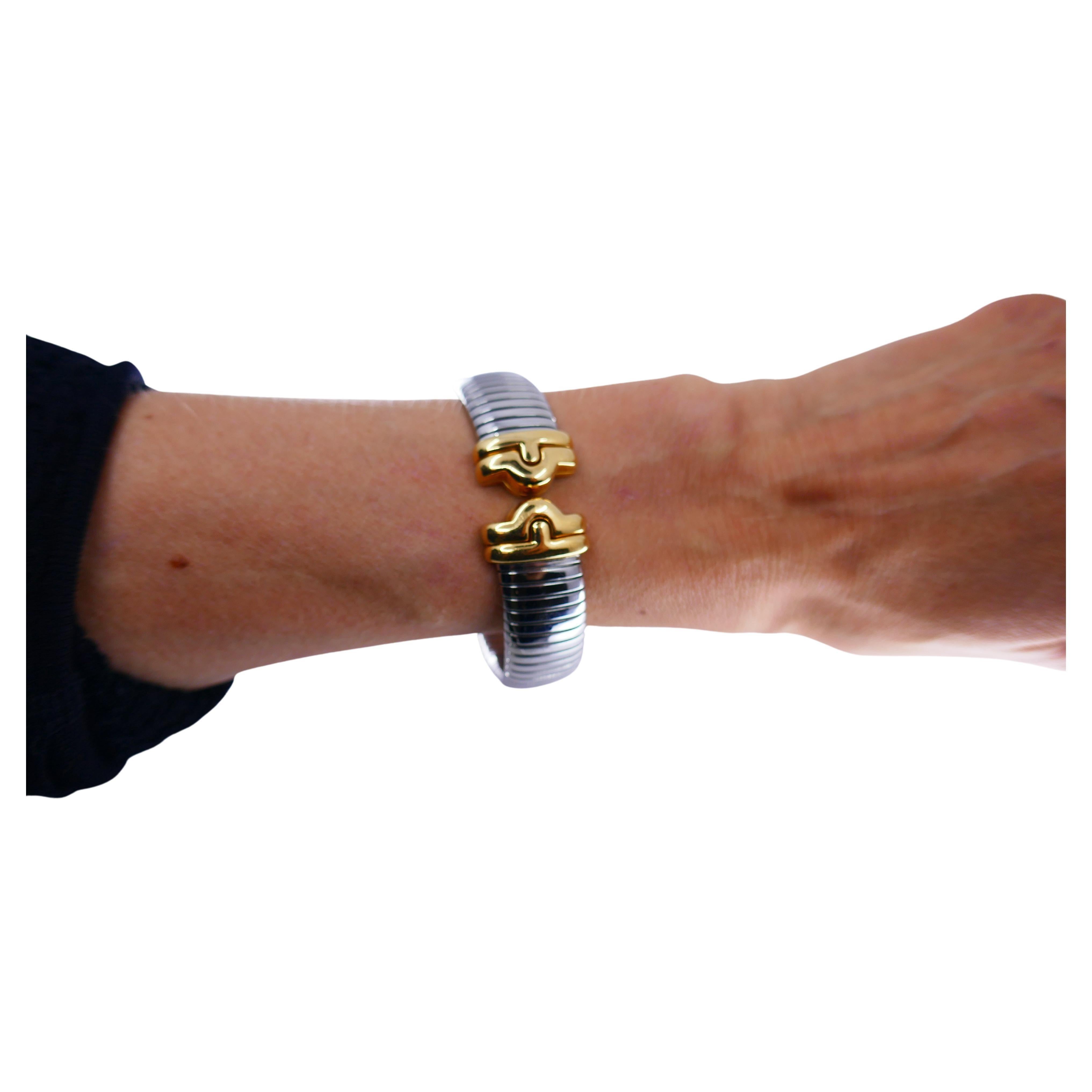 An amazing Bulgari Tubogas bracelet made of stainless steel and 18k gold. Belongs to Bulgari Parentesi collection.
The body is stainless steel. Gold ends of the bracelet are geometrical Parentesi pattern,
The combo of the white sparkly steel and