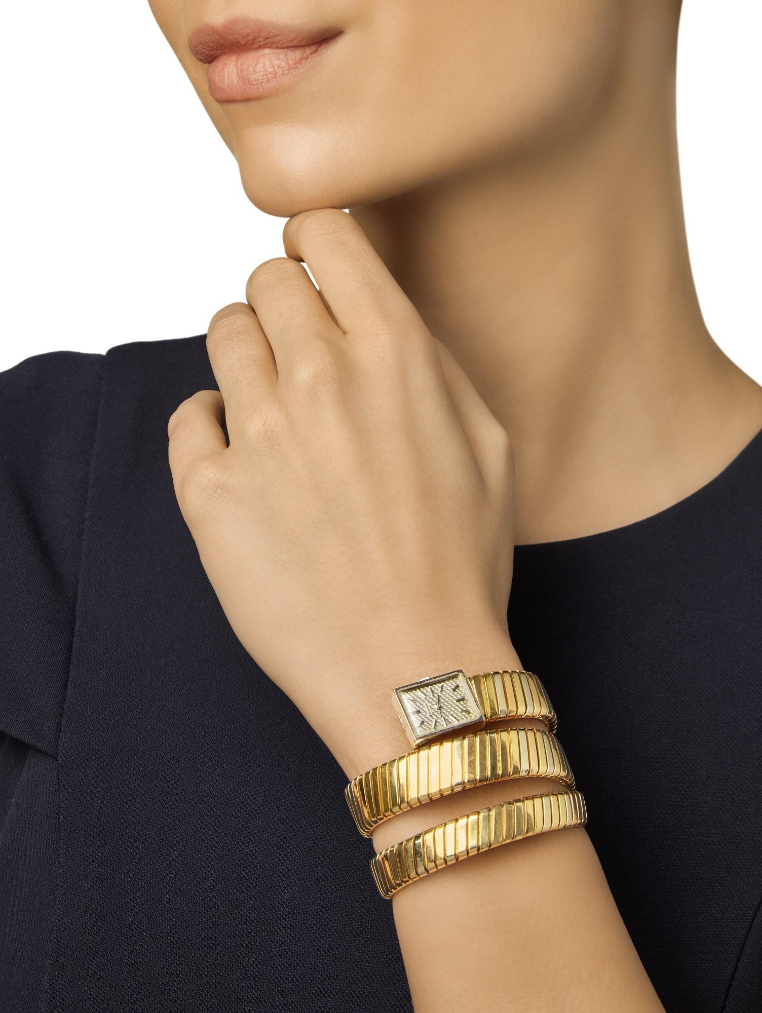 A chic coiled tri-colored gold tubogas bracelet terminating in a rectangular dial with black enameled baton indicators, manual movement. Made in Italy.