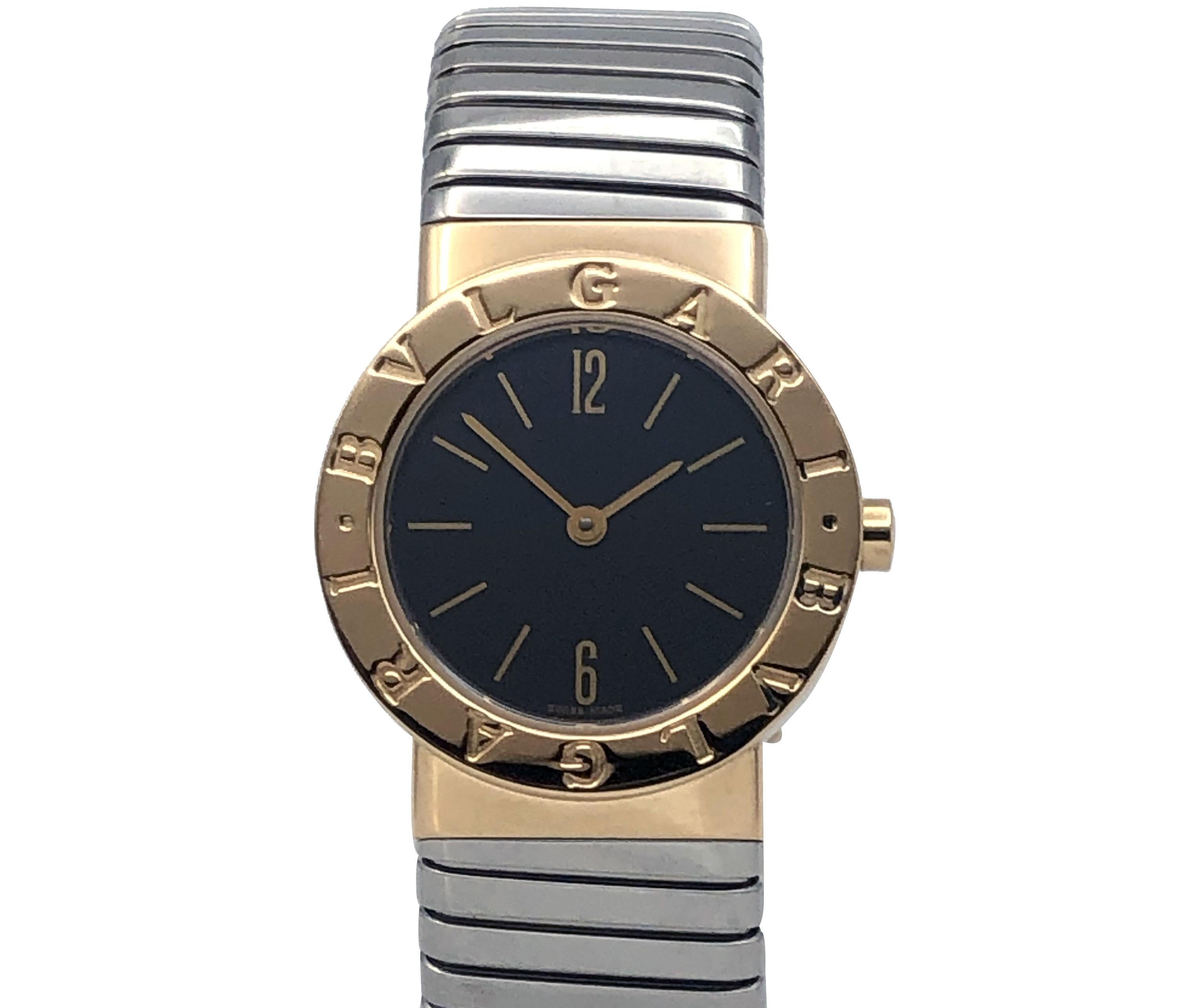 Circa 2000 Bulgari Tubogas Ladies Wrist Watch, 26 M.M. 18k Yellow Gold 2 Piece case, Quartz movement, Black Dial, Stainless steel with 18k Gold end pieces 5/8 inch wide flexible bracelet. Wrist size 5 1/2 to 6 1/2 inches. Comes in the original