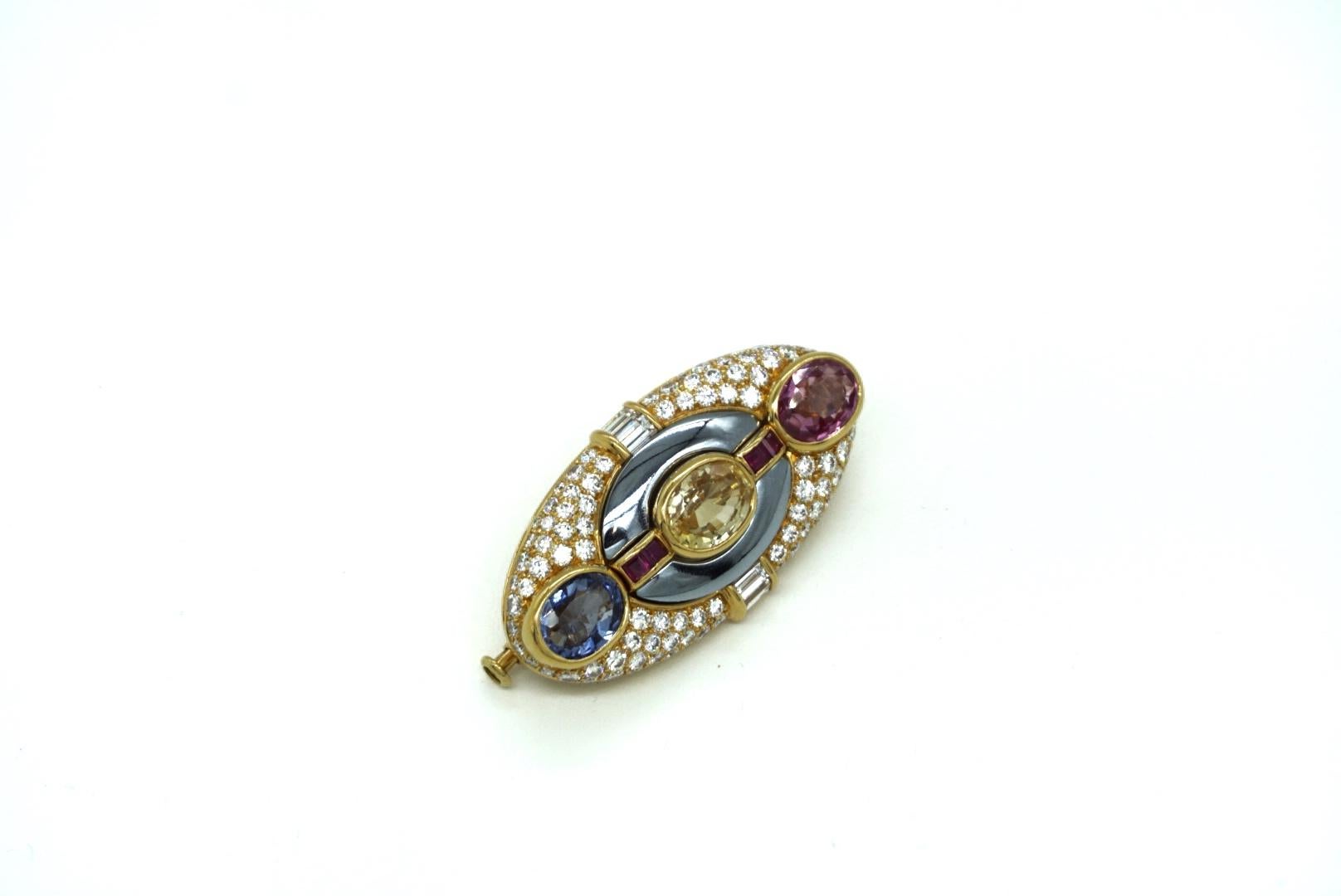 A rare Bulgari brooch of geometrical design, with diamonds, hematite, a blue sapphire (3.22 cts), a yellow sapphire (3.57 cts), and a pink sapphire (3.03 cts) mounted on 18k gold. Made in Italy, circa 1980.