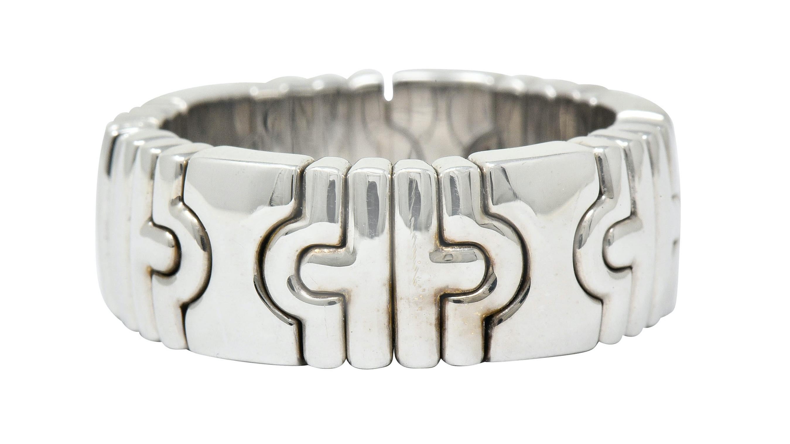 Wide band ring with a flexible cuff-like fit

Comprised of curved chevron links alternating with an hour glass motif

Fully signed Bvlgari and stamped Made in France

With French maker's mark and stamped 750 for 18 karat gold

Circa: 1990s

Ring