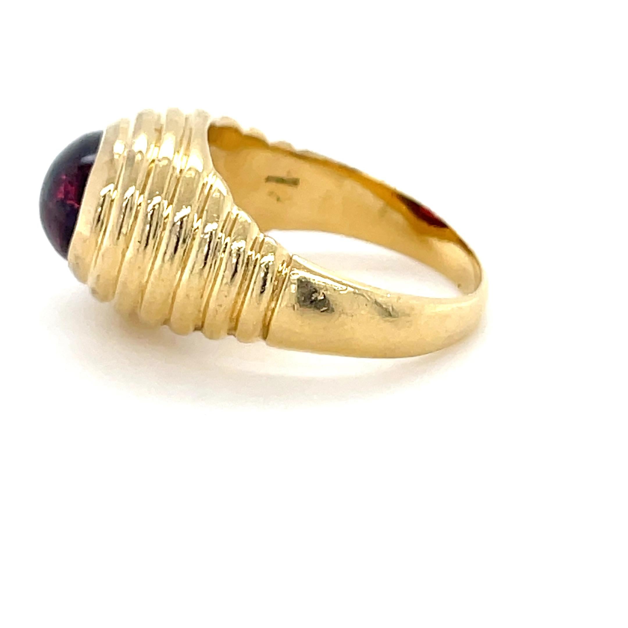 This classic ring by Bulgari features a gorgeous oval cabochon rubelite measuring approximately 10.20 x 7.80 x 4.85 mm and weighing 4.15 carats. Mounted in 18 karat yellow gold in a ridged design, this ring is sure to impress!

Stamp: BVLGARI