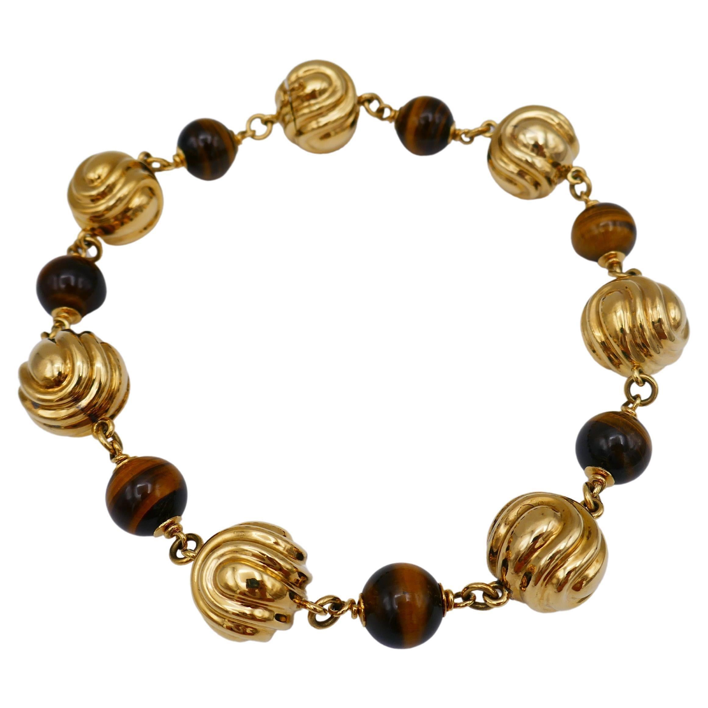 A bold and ballsy gold necklace by Bulgari featuring tiger's eye.
Its glossy silky polish shines and radiates miles away, so this piece is certainly a show stopper.
The gold balls have a beautiful wavy texture. 
The necklace sits perfectly on a