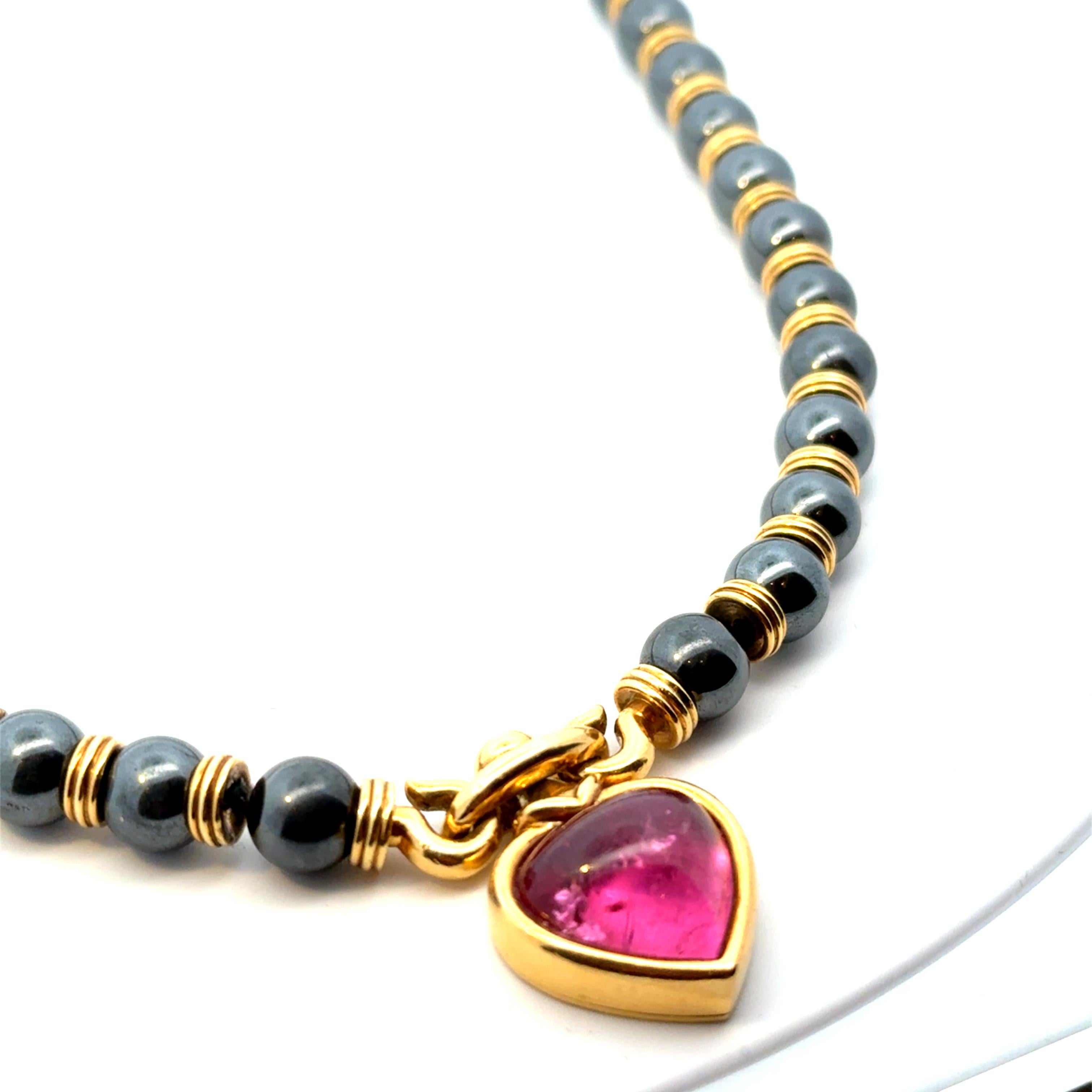 Seltene und einzigartige 18 Karat Gelbgold Hämatit-Halskette. Die Halskette verfügt über eine sehr feine herzförmige Cabochon Pink Turmalin Gewicht ca. 20 cts  schön akzentuiert durch einen Ständer mit goldenen  Rondellen und Hämatitkugeln.
Signiert