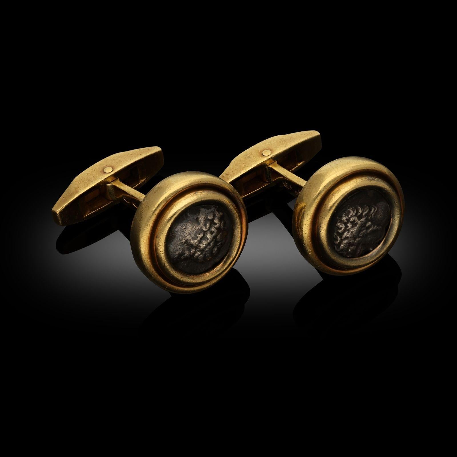 A pair of vintage 'Monete' cufflinks in 18ct yellow gold by Bulgari, circa 1990. These cufflinks are each designed with an ancient silver Gallic coin in a 18ct yellow gold rounded bezel setting and with swivel hinged torpedo backs. The underside of
