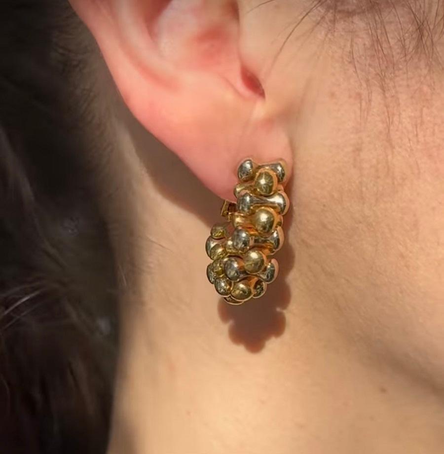 An impressive pair of Bulgari 18k white and yellow gold Bone earrings. 
The earrings' design is bold and sculptural, with a playful arrangement of bone-shaped details that create a three-dimensional effect. The white gold accents add a beautiful