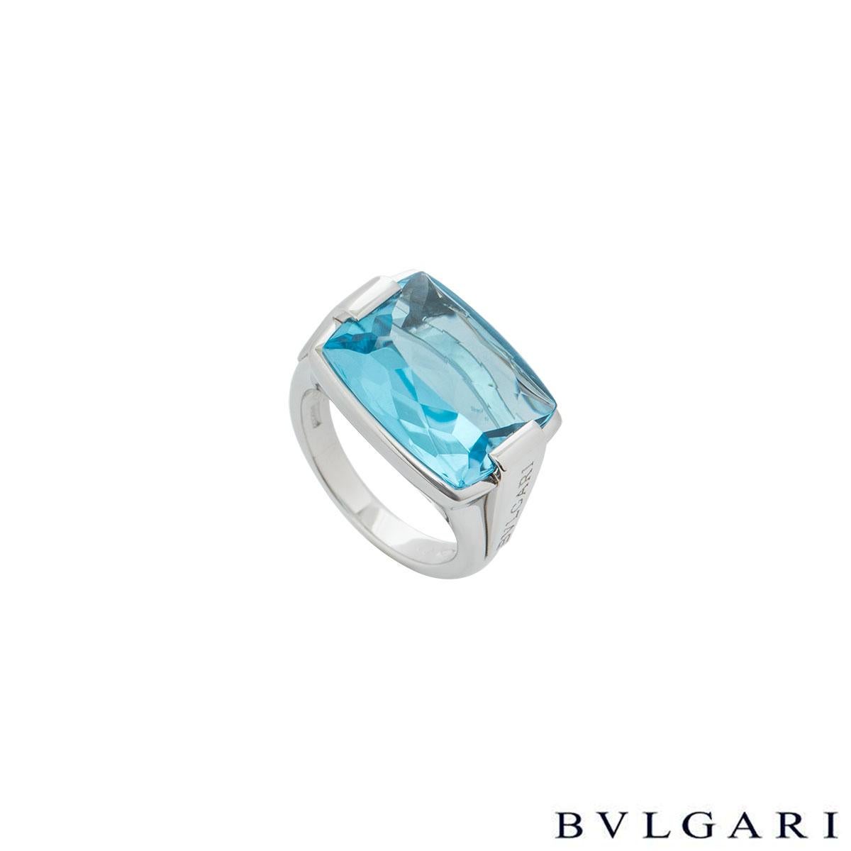 A stunning 18k white gold blue topaz ring by Bvlgari. The ring is set to the centre with rectangular shaped cabochon cut blue topaz weighing approximately 14.50ct, set within tension set shoulders which are engraved with the iconic 'Bulgari Bvlgari'