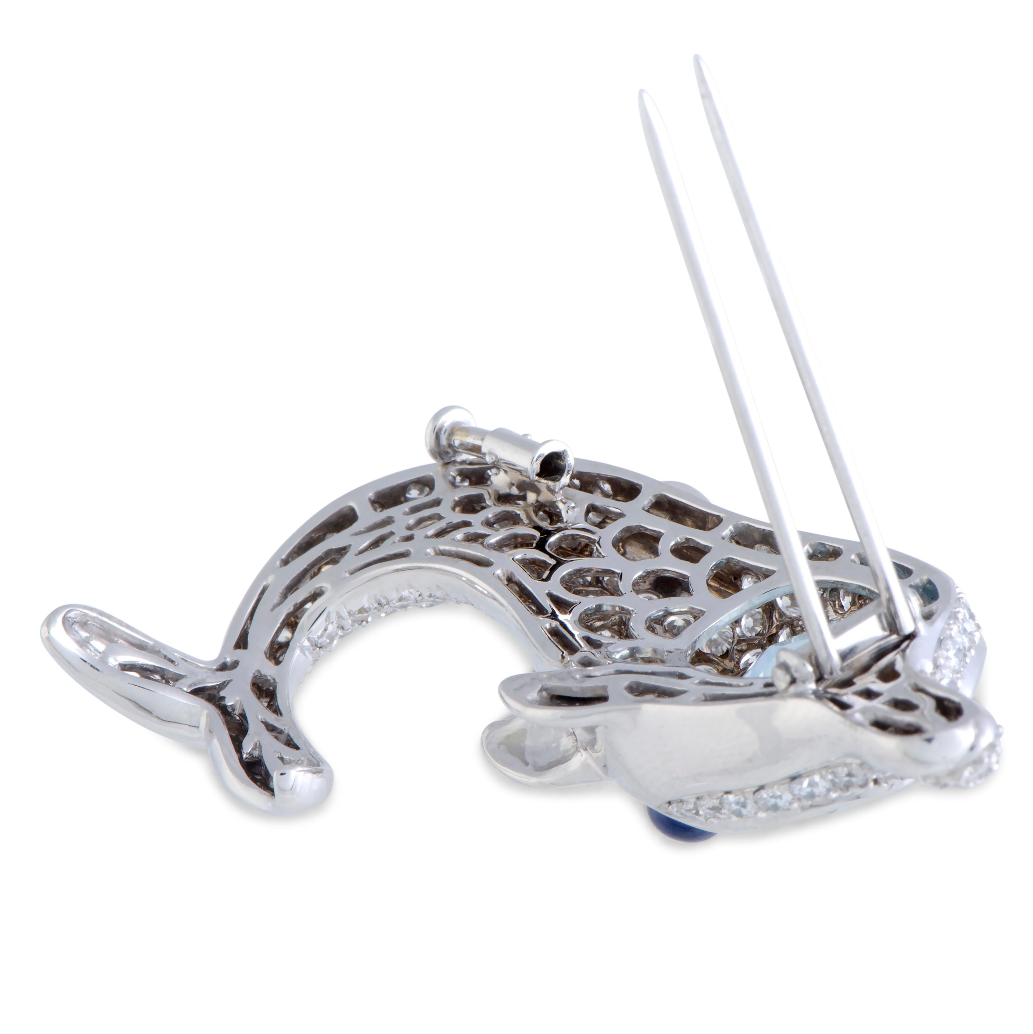 Beautifully crafted in shimmering 18K white gold, this gorgeous dolphin brooch is Bvlgari's wonderful creation. The exemplary item is embellished with a spectacular aquamarine, weighing 12.95ct, a captivating sapphire, and 8.50ct of dazzling