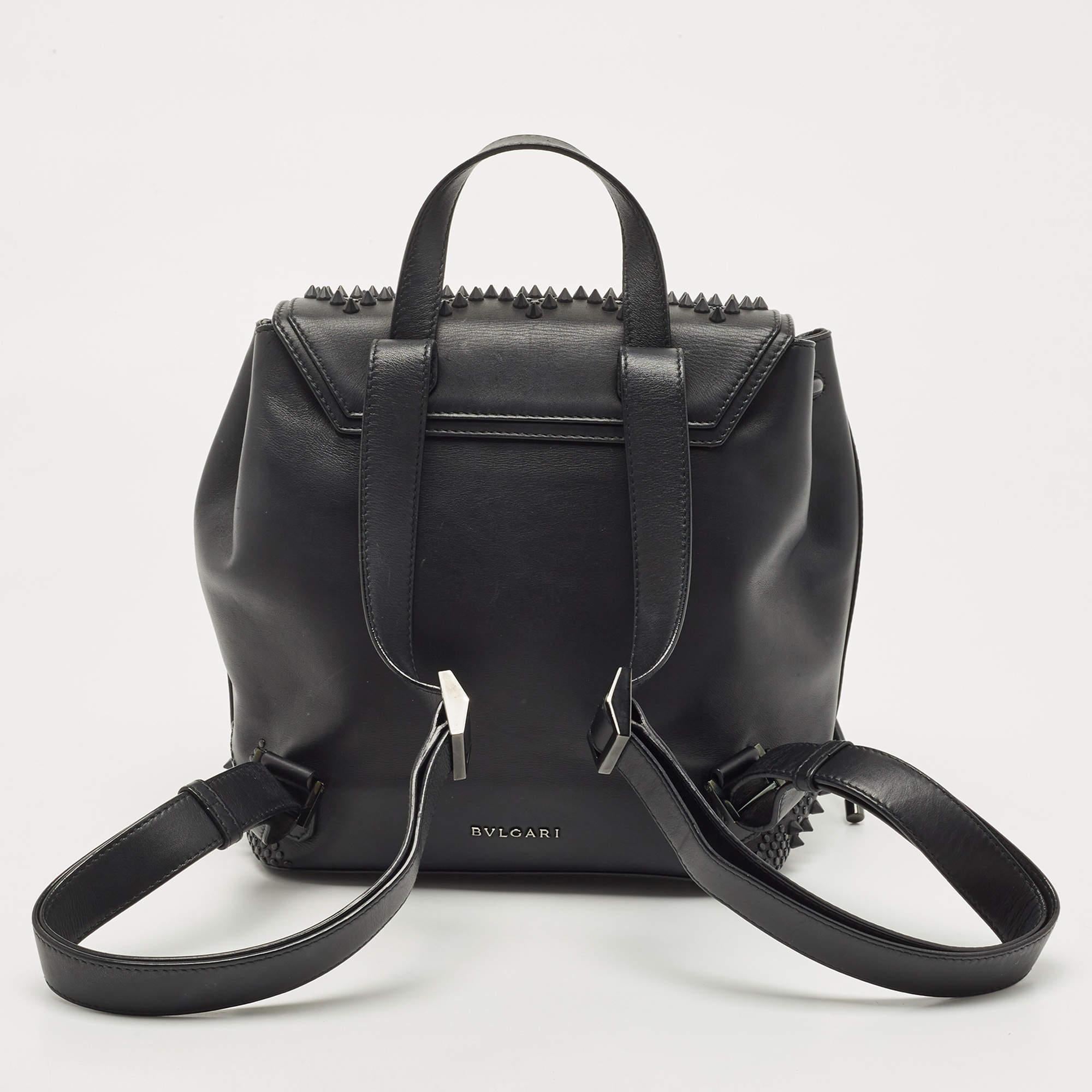 Bvlgari X Nicholas Kirkwood brings this black leather backpack. It is stylish, appealing, and highly practical. The backpack has beautiful embellishments all over, a top handle, two shoulder straps, and a front flap with the Serpenti head