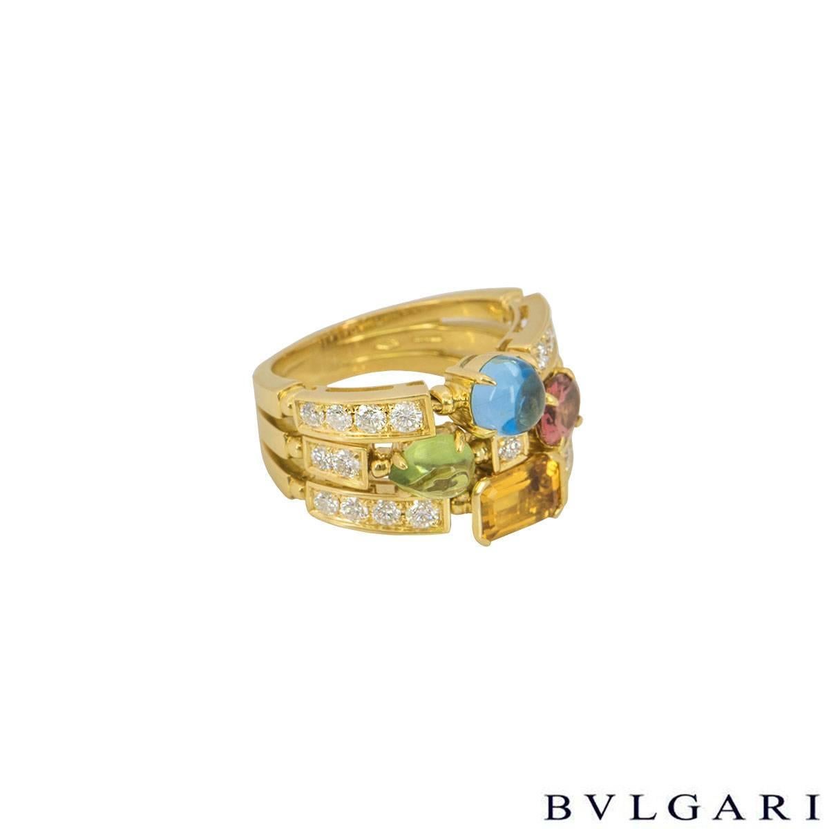 An elegant 18k yellow gold Bvlgari ring from the Allegra collection. The ring compromises of a 3 band setting featuring 4 semi-precious gemstones including pink tourmaline, peridot, citrine quartz and blue topaz. The gemstones are complimented by 21