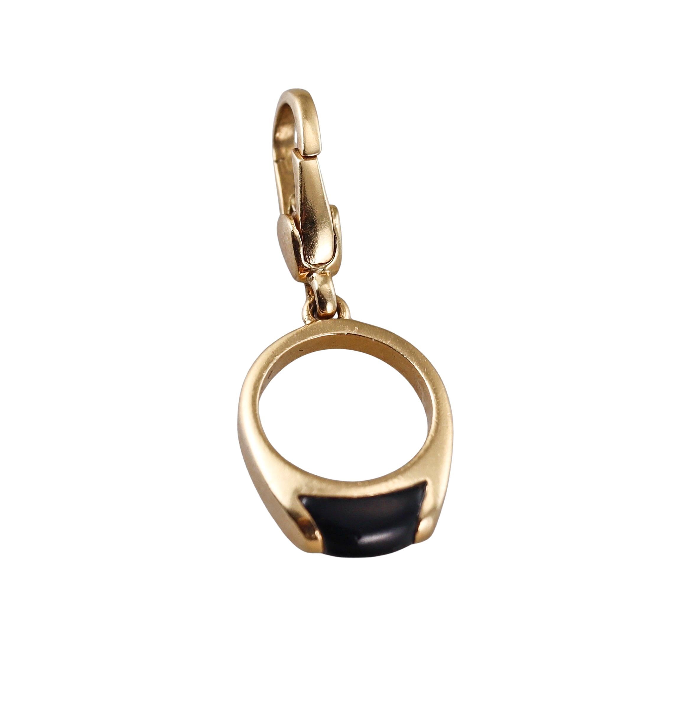 An 18k yellow gold charm pendant by Bvlgari with onyx, depicting a Tronchetto ring. Pendant is 31mm long with bale , ring is 14mm x 16mm.  Marked Bvlgari, made in Italy, 750. Weight - 3.3 grams. 
