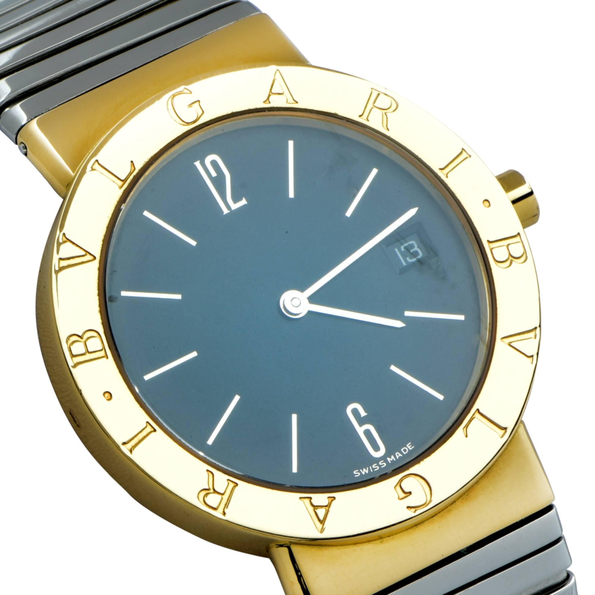 From the House of Bvlgari, this sleek Tubogas 18 Karat Yellow Gold and Stainless Steel Quartz watch with date, features a round black face framed in 18 karat yellow gold, measuring 33 mm in diameter with an adjustable stainless steel bracelet strap