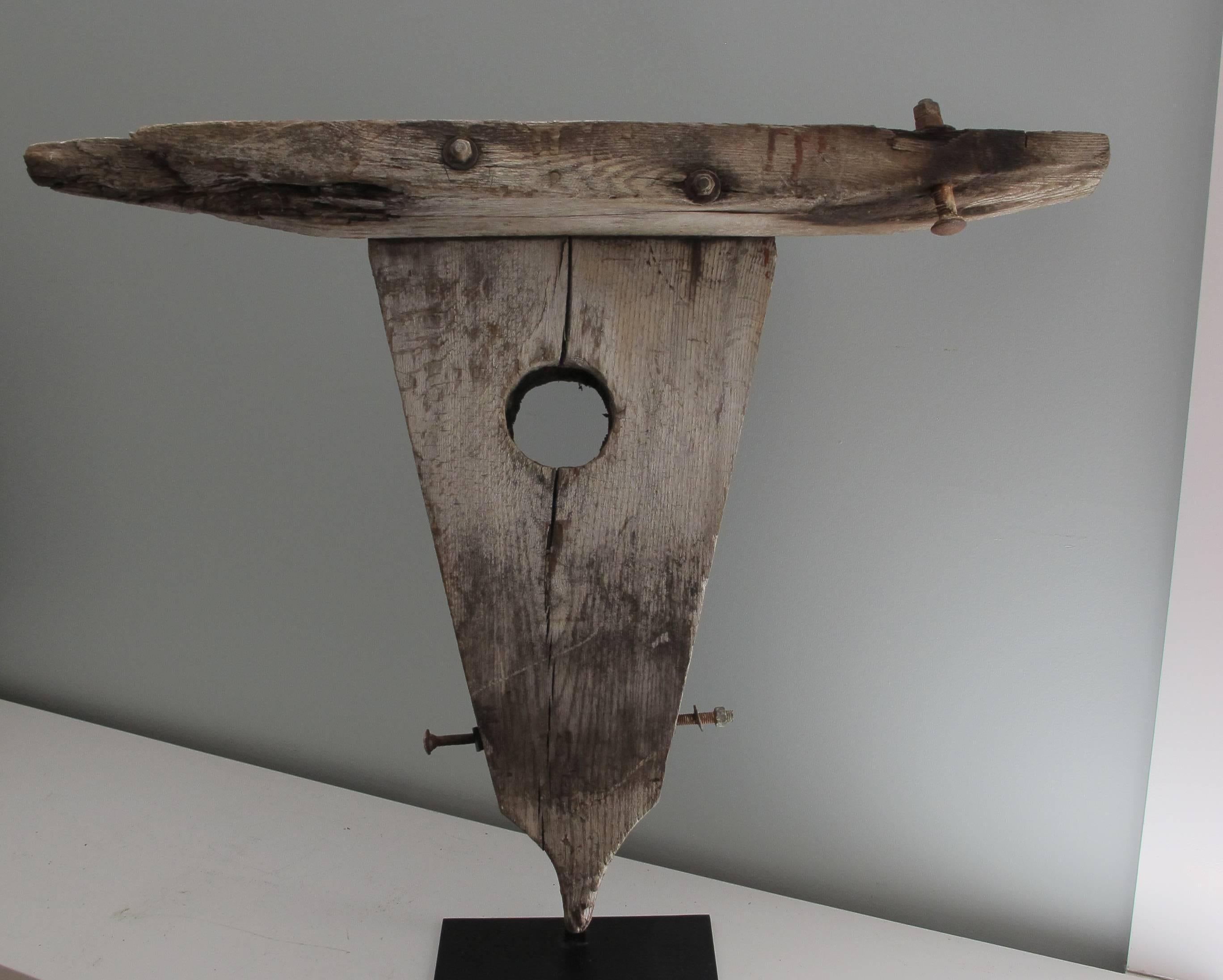 An old found wood sculptural form of a bull 's head mounted over a metal base. Made of an elongated triangular
