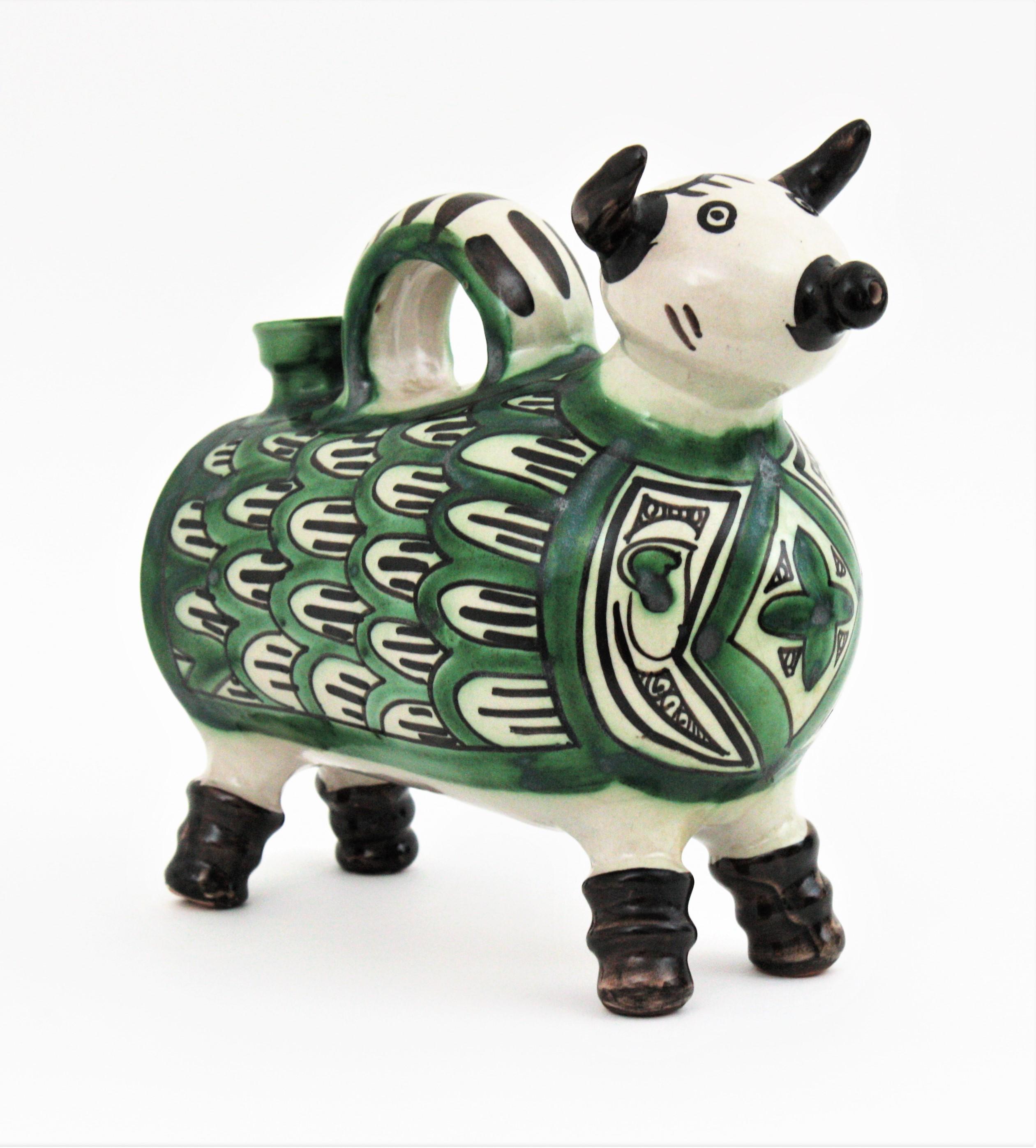 Eye-catching ceramic bull jug / pitcher, Spain, 1960s.
Spanish ceramic bull shaped jug with romanesque inspired decorative details in green, white and brown-black.
This kind of traditional spanish jug was designed to contain water and to preserve it