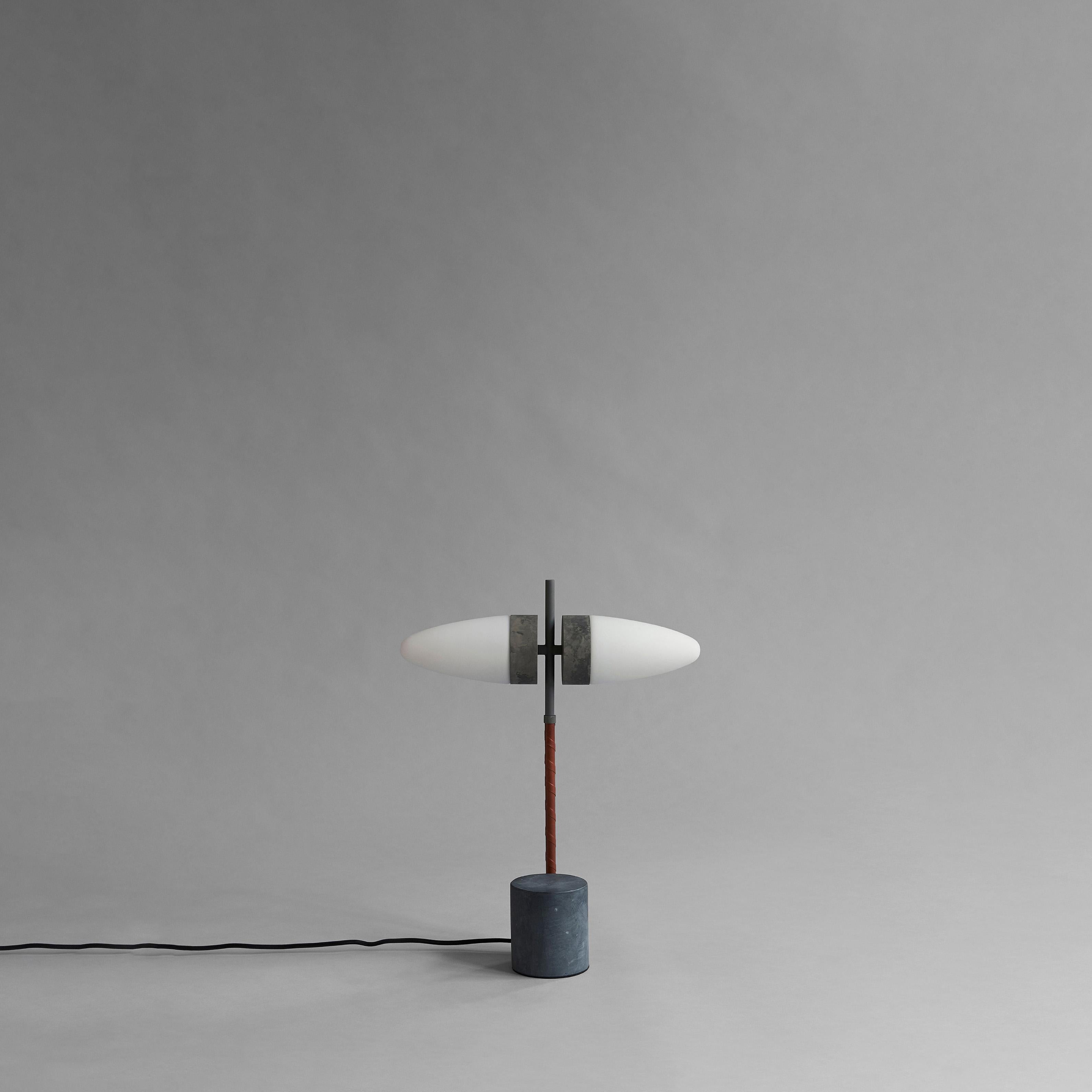 Bull table lamp by 101 Copenhagen.
Designed by Kristian Sofus Hansen & Tommy Hyldahl.
Dimensions: L 38 x W 12 x H 50 cm.
Cable length: 200 cm.

Materials: metal: aliminum / oxidized
Opal glass / white
Leather / Cognac
Cable: Fabric covered cable