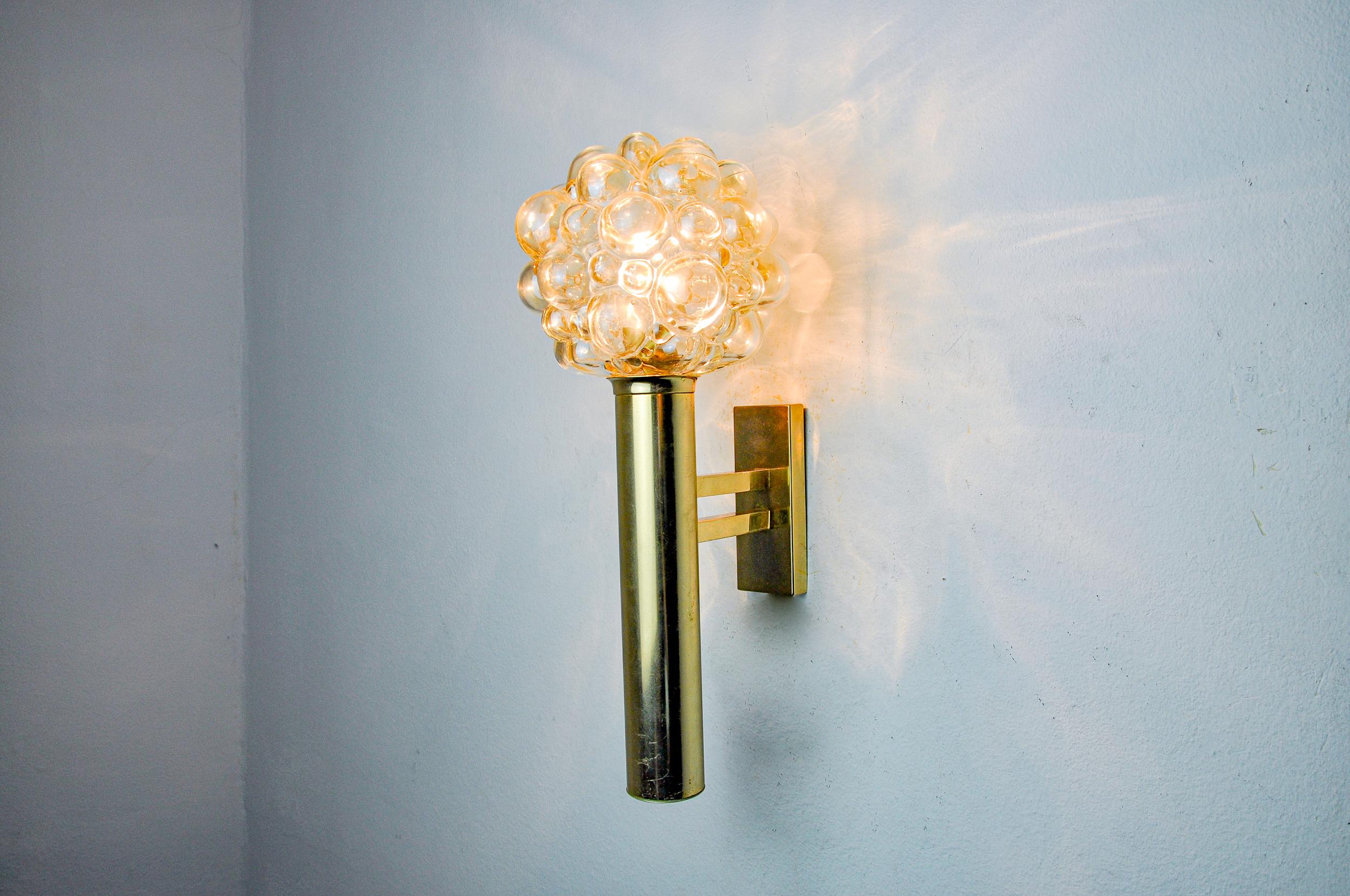 Superb bubble wall lamp by Helena Tynell for Limburg designed and produced in Germany in the 1970s. Gold metal structure supporting a hand-blown amber-coloured glass globe called 