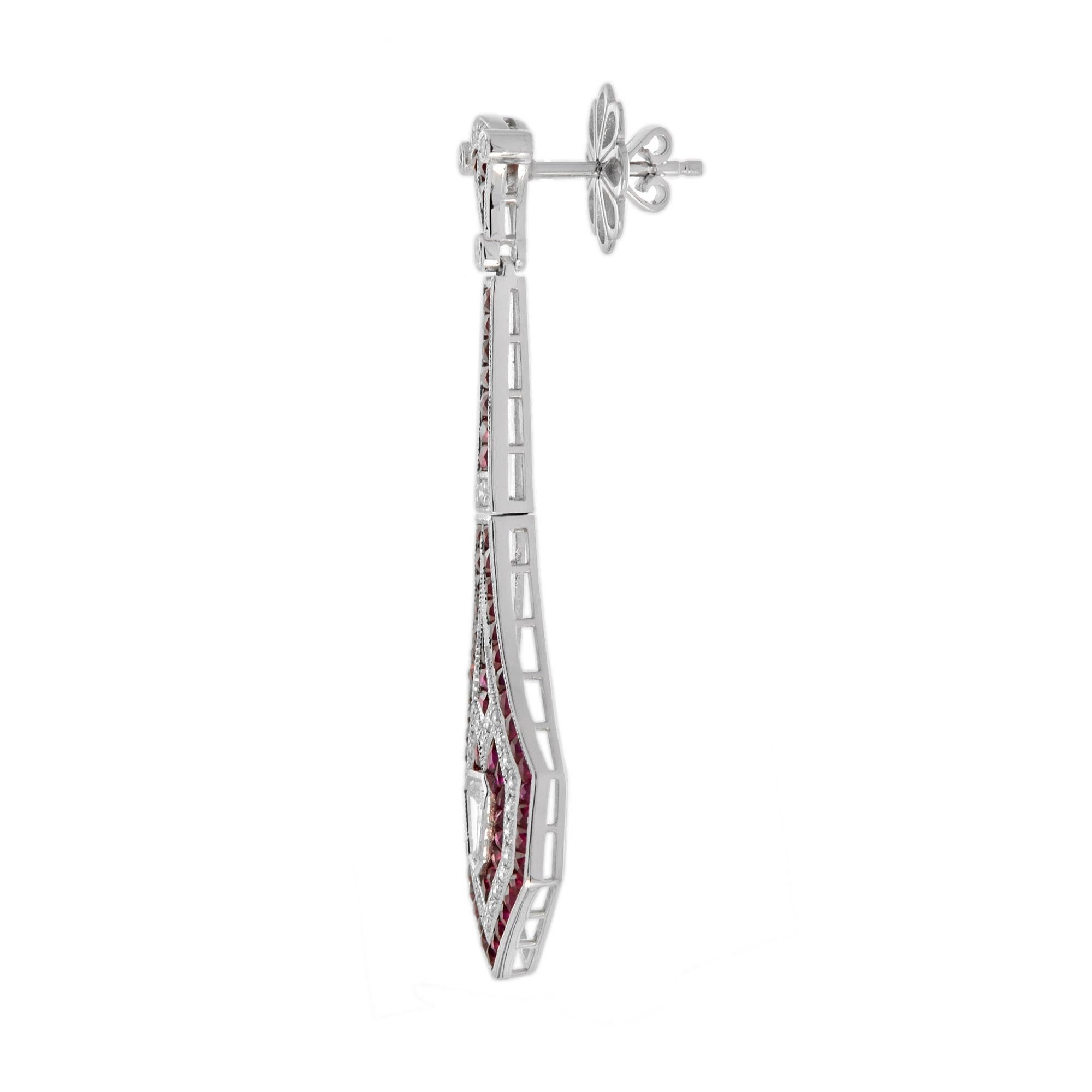 Un favoloso paio di orecchini con diamanti e rubini in stile Art Deco. Questi orecchini a goccia contengono 0,47 carati di diamanti a forma di proiettile con colore H e purezza SI e 6,90 carati totali di rubini rossi taglio francese. Sono