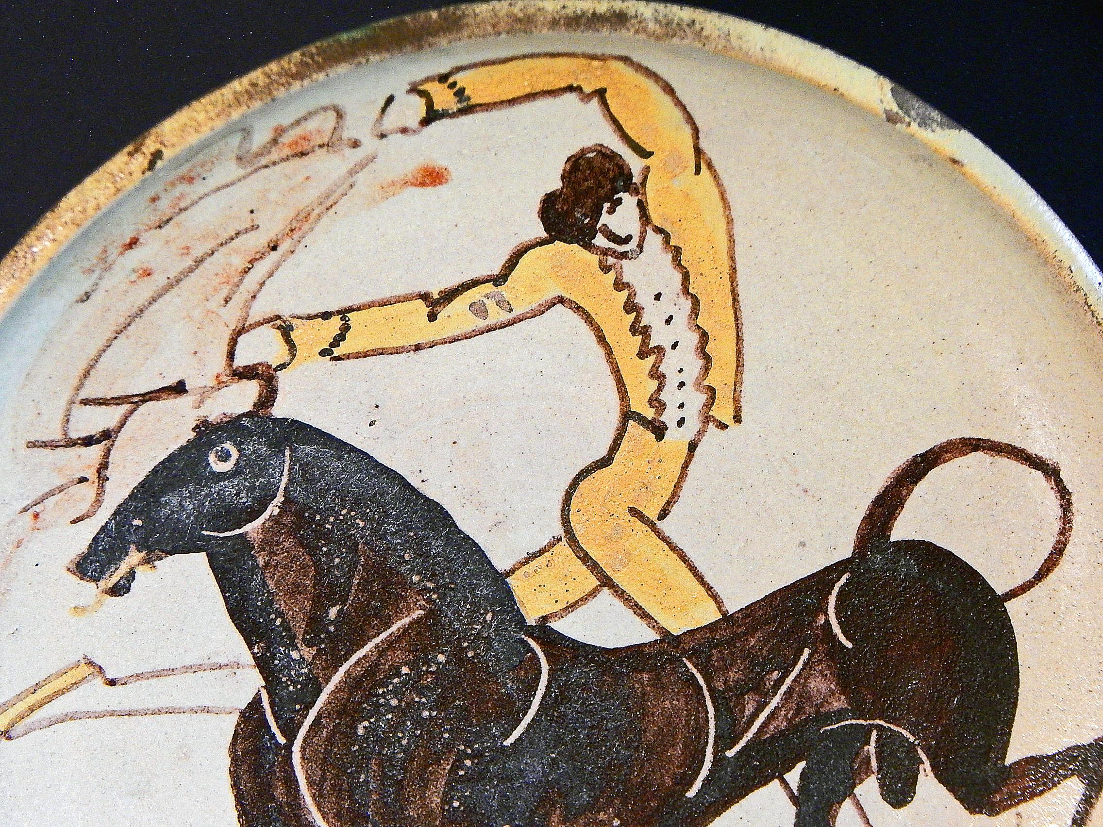 Exemple coloré et brillant de l'art de William Hunt Diederich - qui présente des personnages très stylisés et atténués - cette coupe émaillée sur pied représente un matador en veste jaune aux prises avec un beau taureau maigre, les cornes du taureau