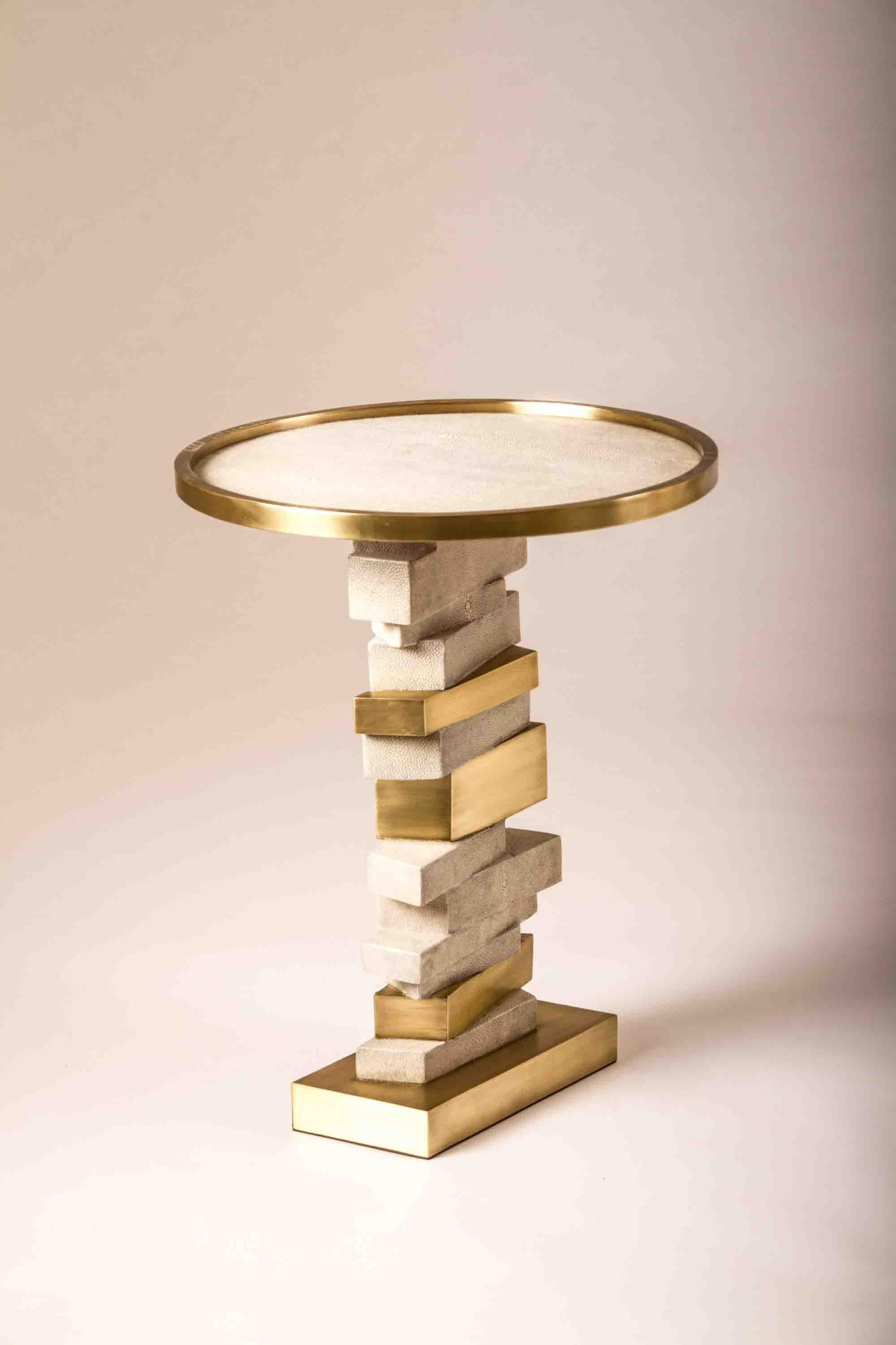 The Bullion side table is inspired by stacked gold bars. The top of the table is inlaid in cream shagreen with a bronze-patina brass frame. The stacked inspired gold bars are inlaid in a mixture of shagreen and brass. This piece makes for a playful