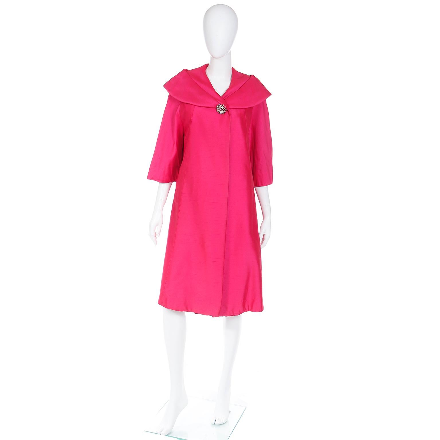 This is a gorgeous vintage 1950's pink evening coat purchased at Bullock's in Westwood at the Weyburn room in the late 1950's. The coat has 3/4 length sleeves, a pleated collar, a giant rhinestone button, side slit pockets, and is fully lined. This