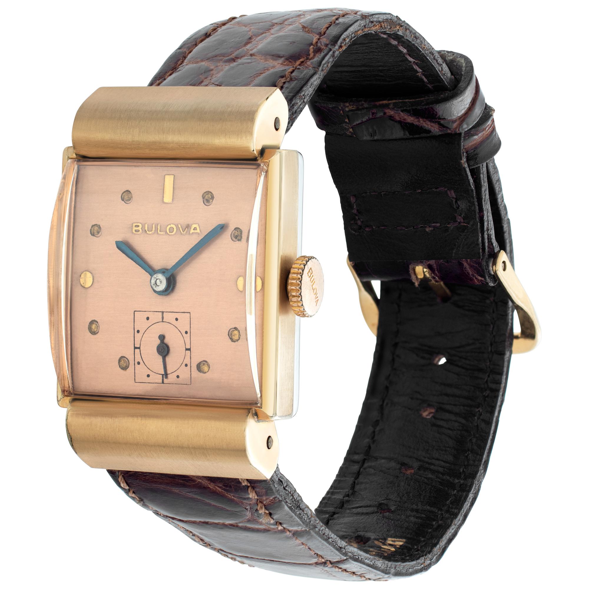 Unisex Bulova gold fill case & bezel with hooded lugs on a leather leather band. Manual wind 17 jewel movement. Circa 1940's. Fine Pre-owned Bulova Watch. Certified preowned Vintage Bulova watch on a Brown Leather band with a Gold Fill tang buckle.