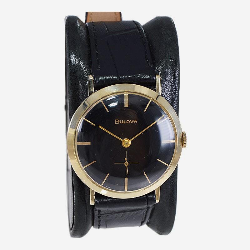 FACTORY / HOUSE: Bulova Watch Co.
STYLE / REFERENCE: Mid Century
METAL / MATERIAL: 14kt Yellow Gold
CIRCA / YEAR: 1960's
DIMENSIONS / SIZE: Length 38mm x Diameter 33mm
MOVEMENT / CALIBER: Manual Winding / 21 Jewels 
DIAL / HANDS: Black Dial / Gold