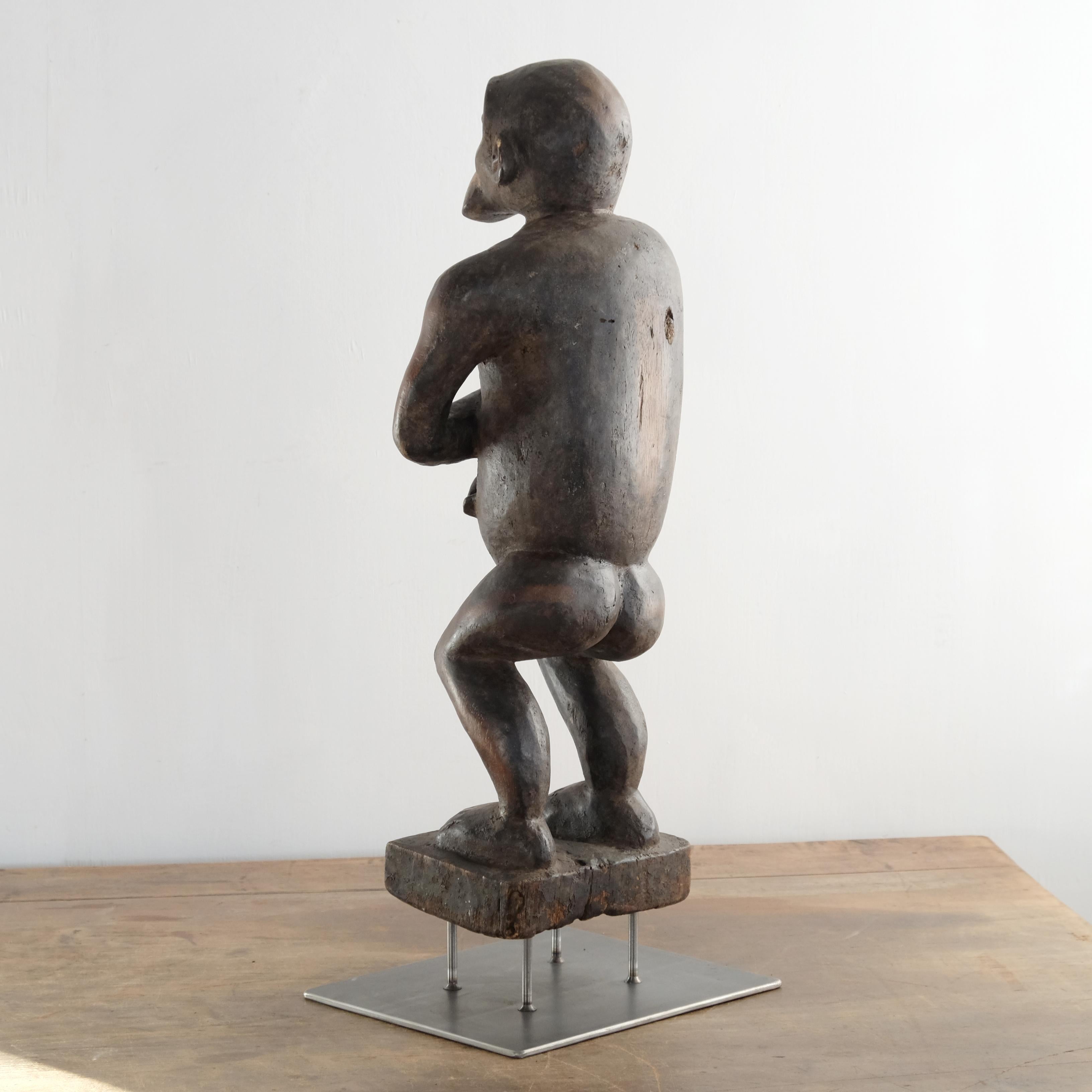 A large, impressive and characterful carved timber monkey by the Bulu tribe of Cameroon and surrounds. The adult monkey is holding a baby, suggesting this might be symbolic of fertility or parenthood. The original paint is clear but has areas of
