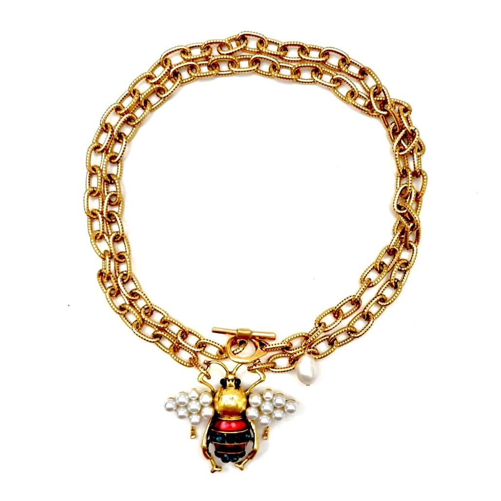 This handcrafted necklace is a stunning, one-of-a-kind creation that truly stands out. The design features a vintage etched circle link chain made from heavy brass, giving it a bold, elegant presence. At its heart, the necklace showcases a vintage