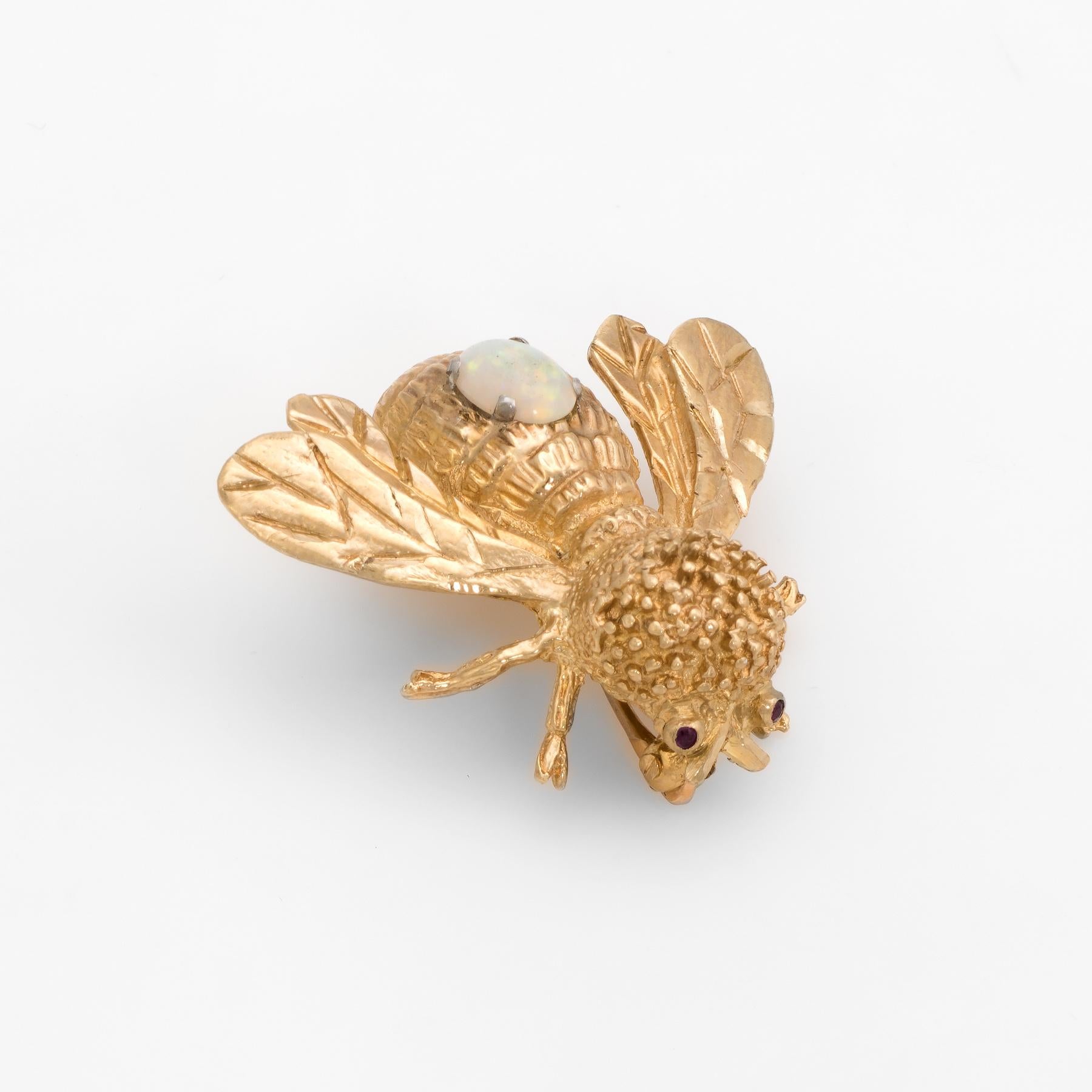 Finely detailed vintage bumble bee brooch, crafted in 14 karat yellow gold.  

Solid natural opal measures 6mm x 5mm (estimated at 0.65 carats). The opal is in excellent condition and free of cracks or chips. Two approx. 0.01 carat garnets adorn the