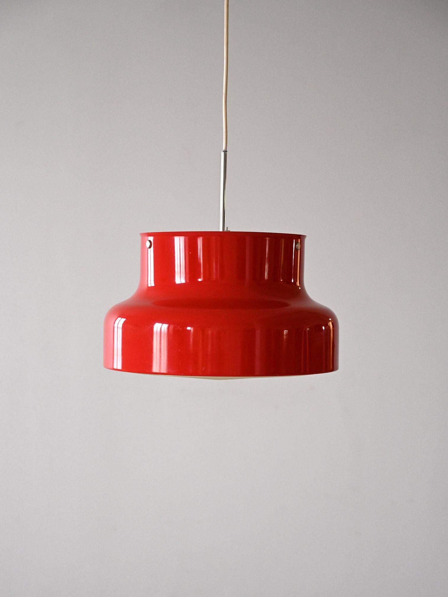 Original Scandinavian red lamp from the 1960s.

 The Bumling model, designed by Anders Pehrson in the 1960s for Ateljé Lyktan, has become iconic because of the special shape of the lampshade, which, thanks to its absolutely contemporary style and