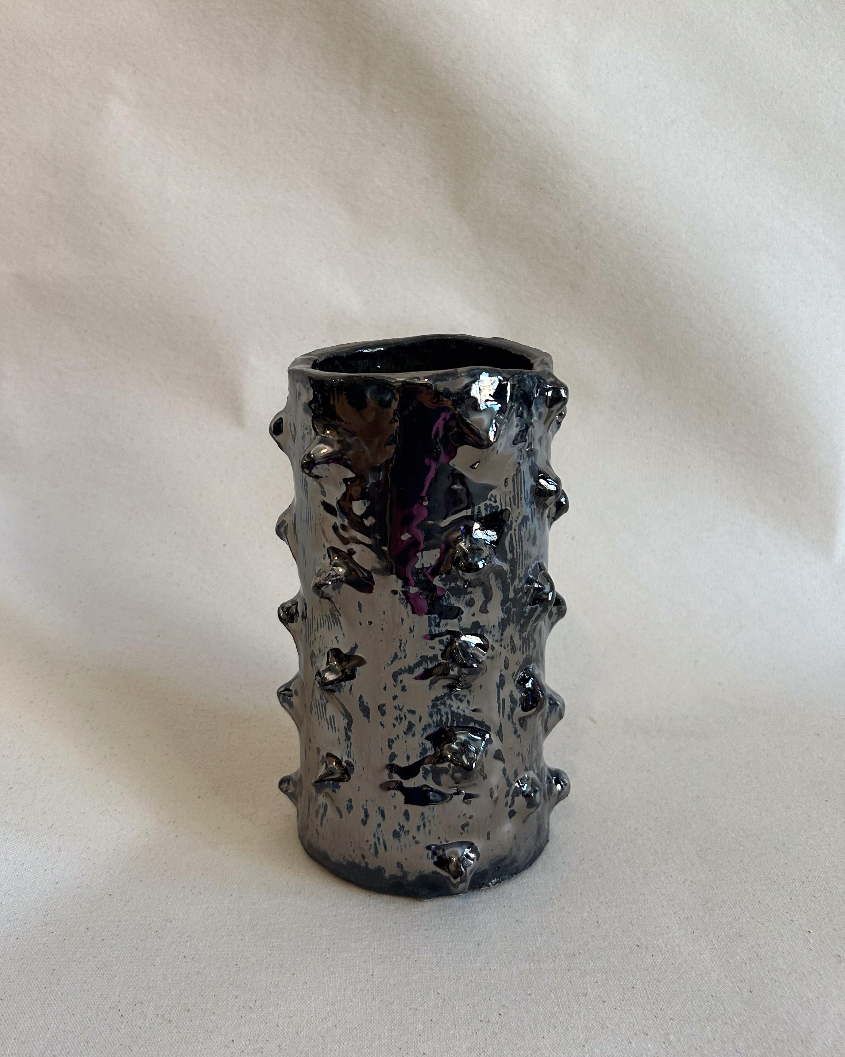 Jarrón cilíndrico 450 fabricado a mano con detalles aplicados en la superficie y un esmalte de espejo muy brillante y cromado.

Cada uno es único, y es posible personalizarlo.